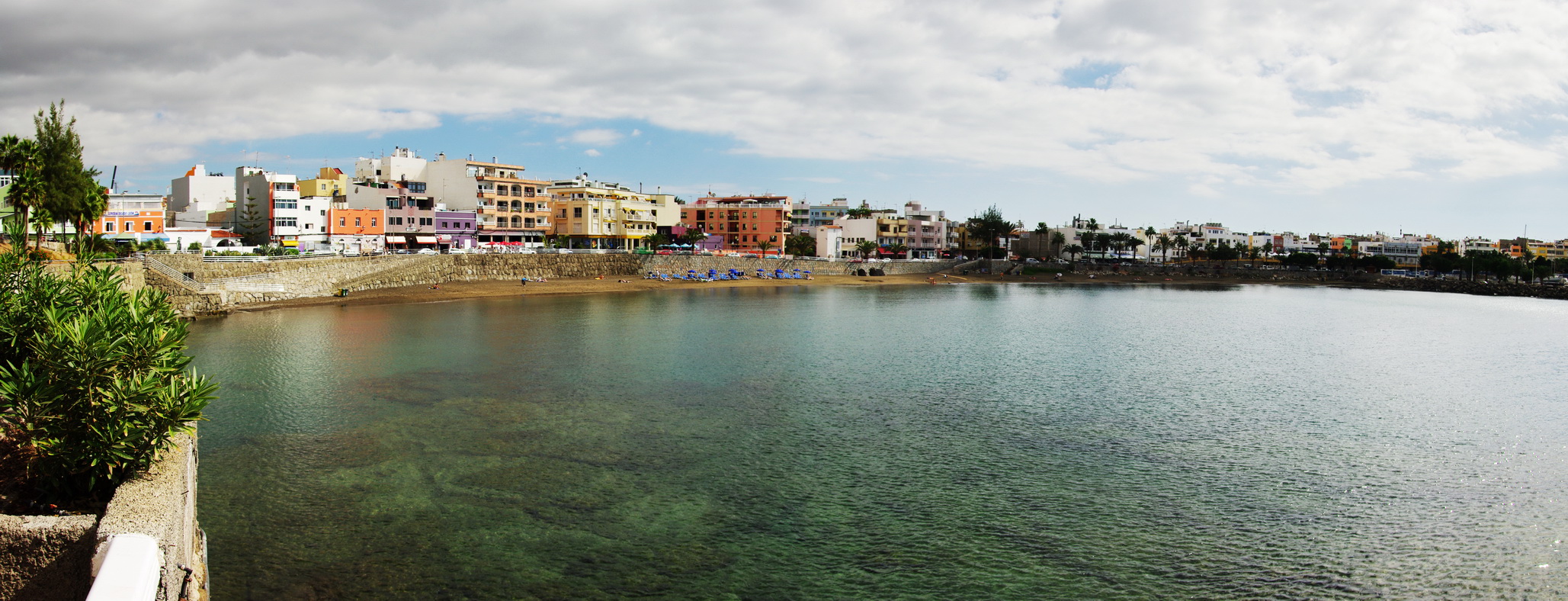 Arguineguín's waterfront displays the characteristic pastel-colored architecture typical of Canarian coastal towns, facing the sheltered bay.