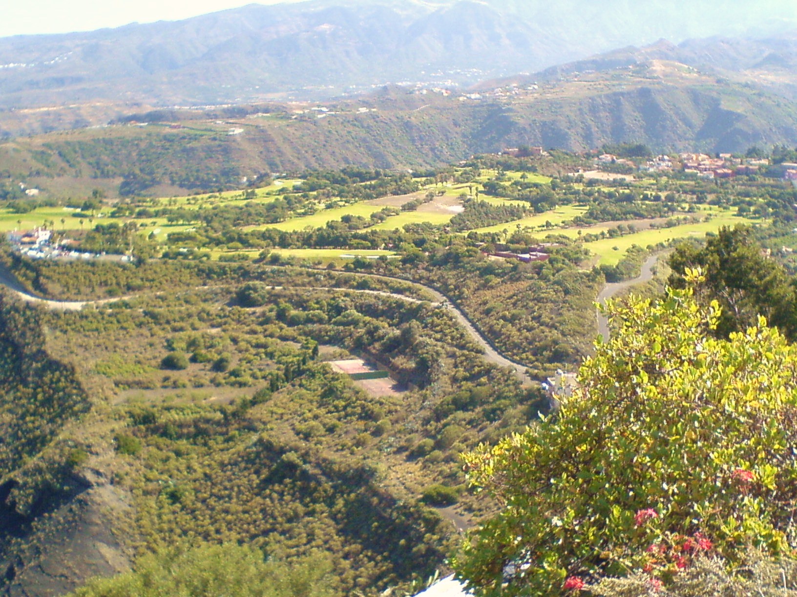 The lush Bandama valley stretches below, its patchwork of farmland and vegetation contrasting with the steep volcanic slopes that frame this elevated panorama.