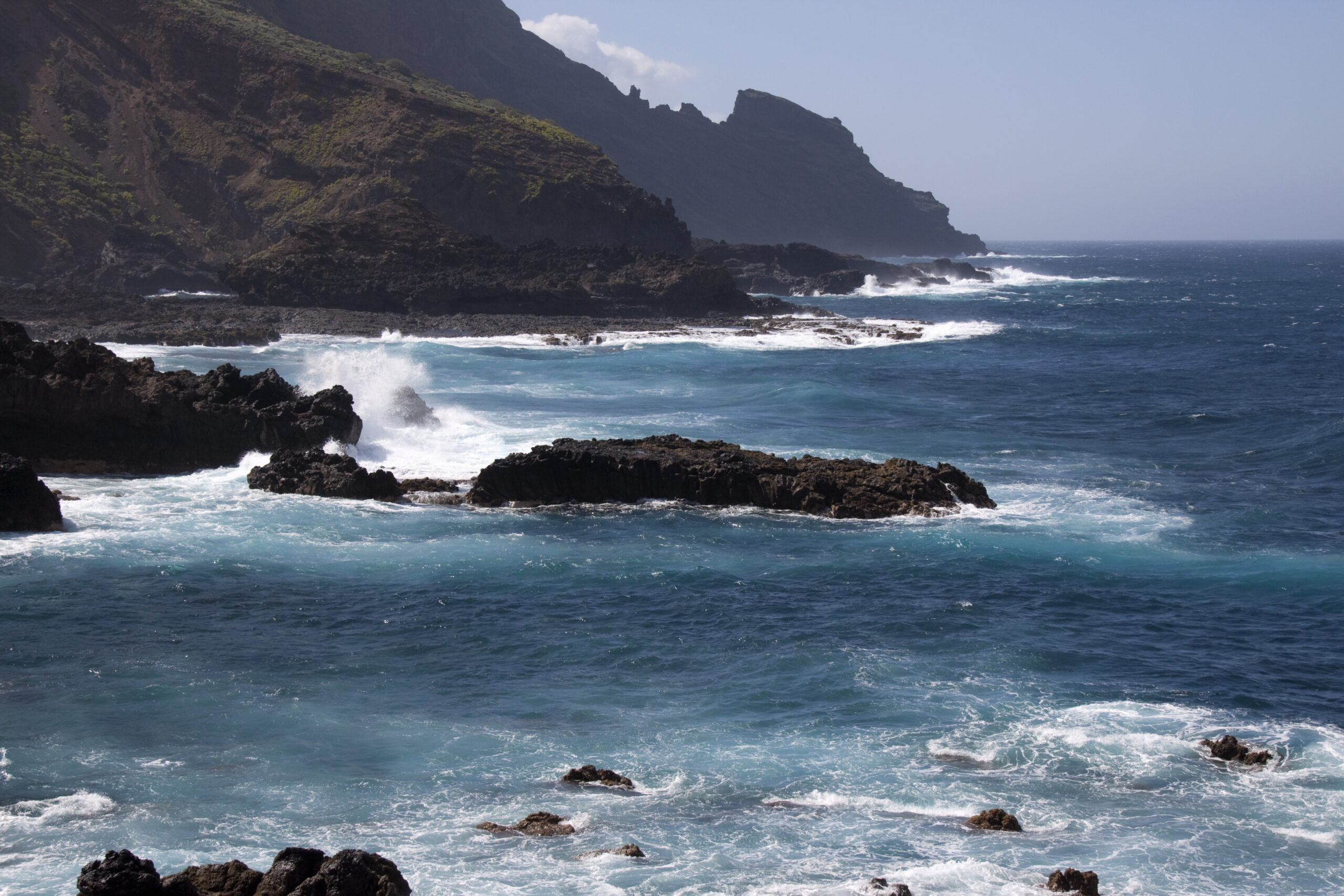 The windward coast of La Palma features dramatic volcanic cliffs and powerful Atlantic swells that crash against dark basalt rocks.