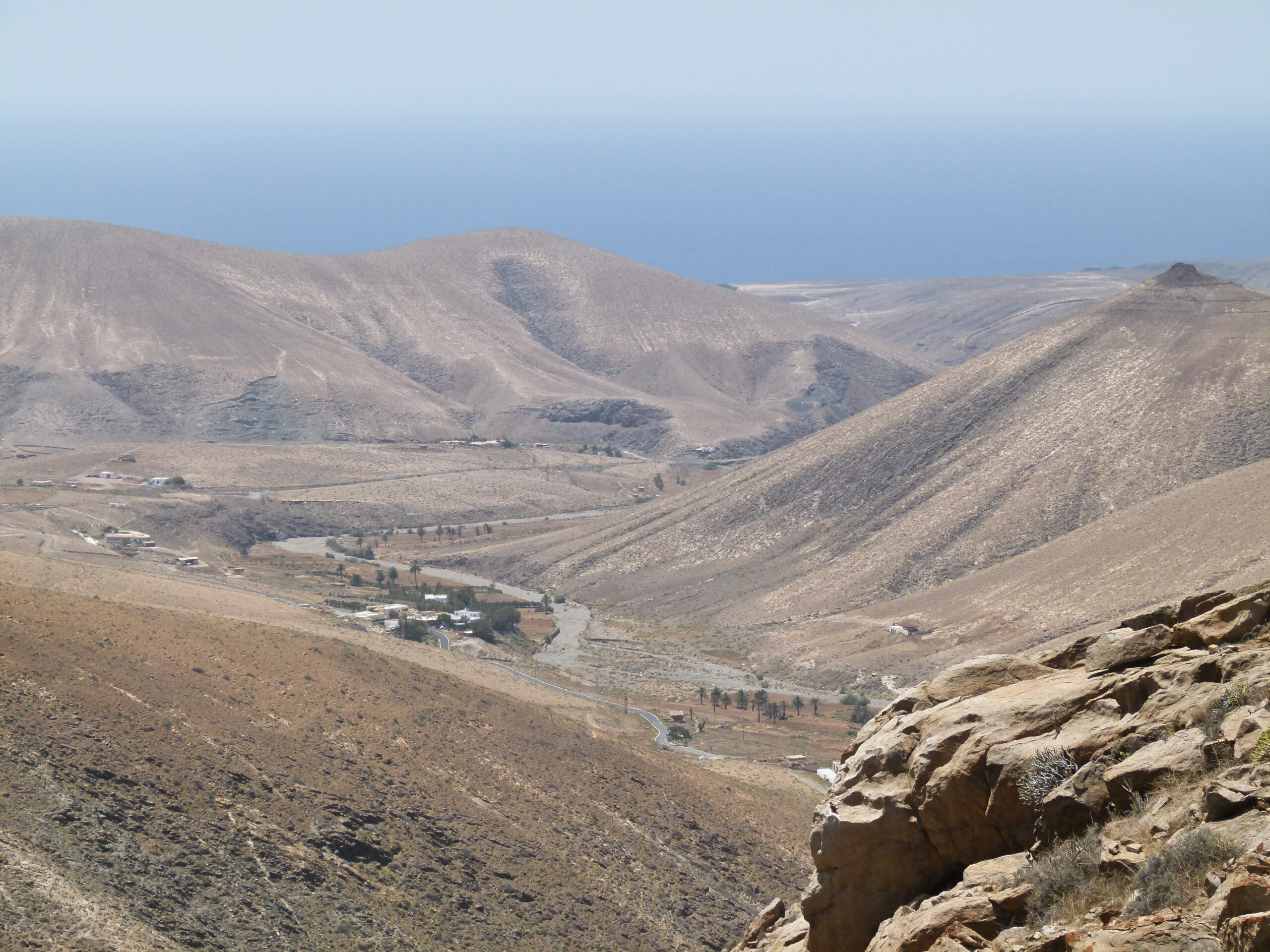The dramatic barranco valley near Betancuria showcases Fuerteventura's stark volcanic terrain with deeply eroded hillsides and scattered settlement.