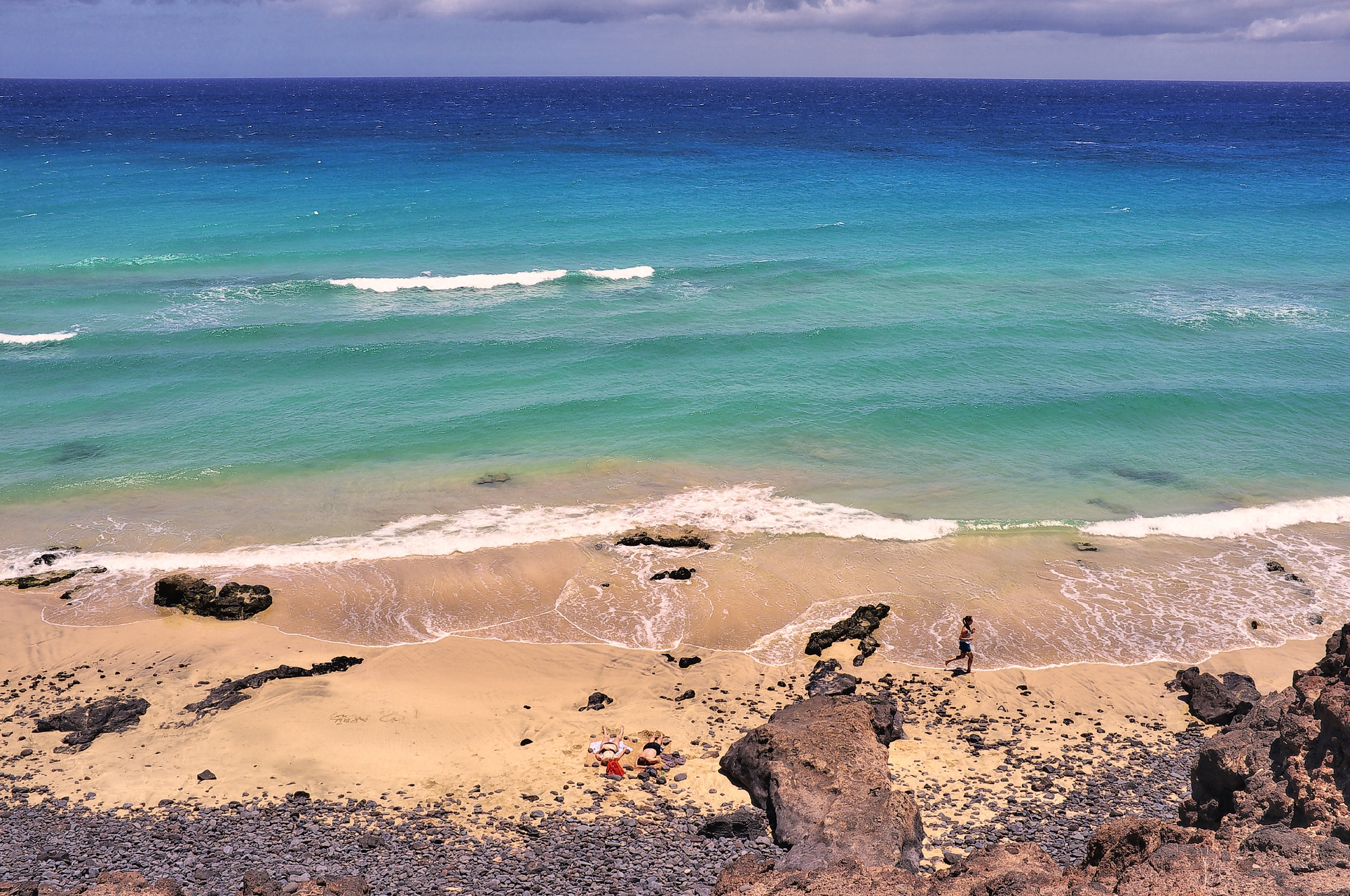 Butihondo Beach in Jandía features golden sand, crystalline turquoise waters, and distinctive volcanic rock formations characteristic of Fuerteventura's coastline.