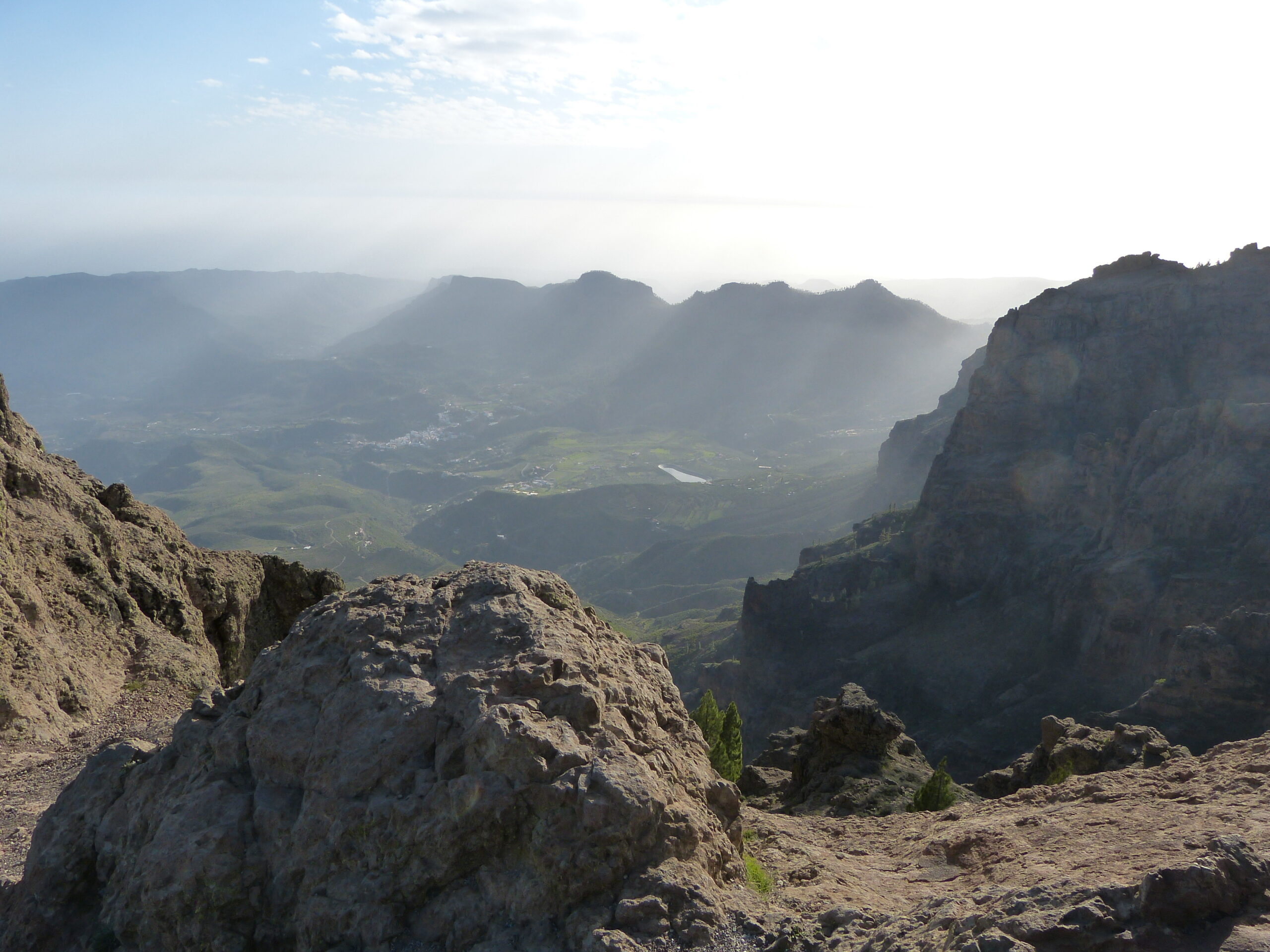 The Caldera de Tirajana unfolds below dramatic rock formations, revealing the fertile valley and surrounding peaks of Gran Canaria's interior.
