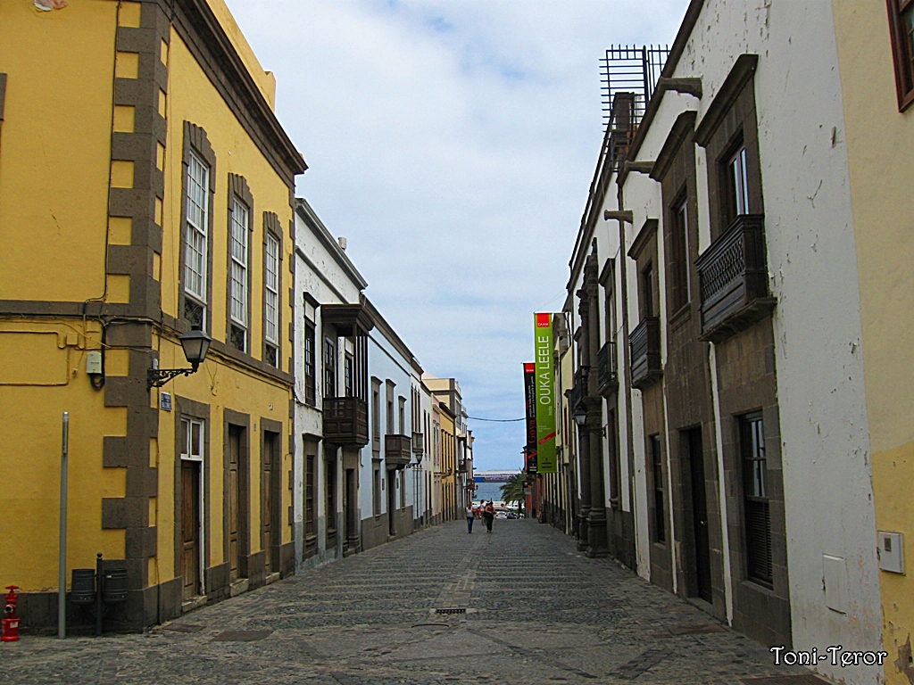 A historic street in Vegueta lined with colourful colonial architecture and traditional wooden balconies.