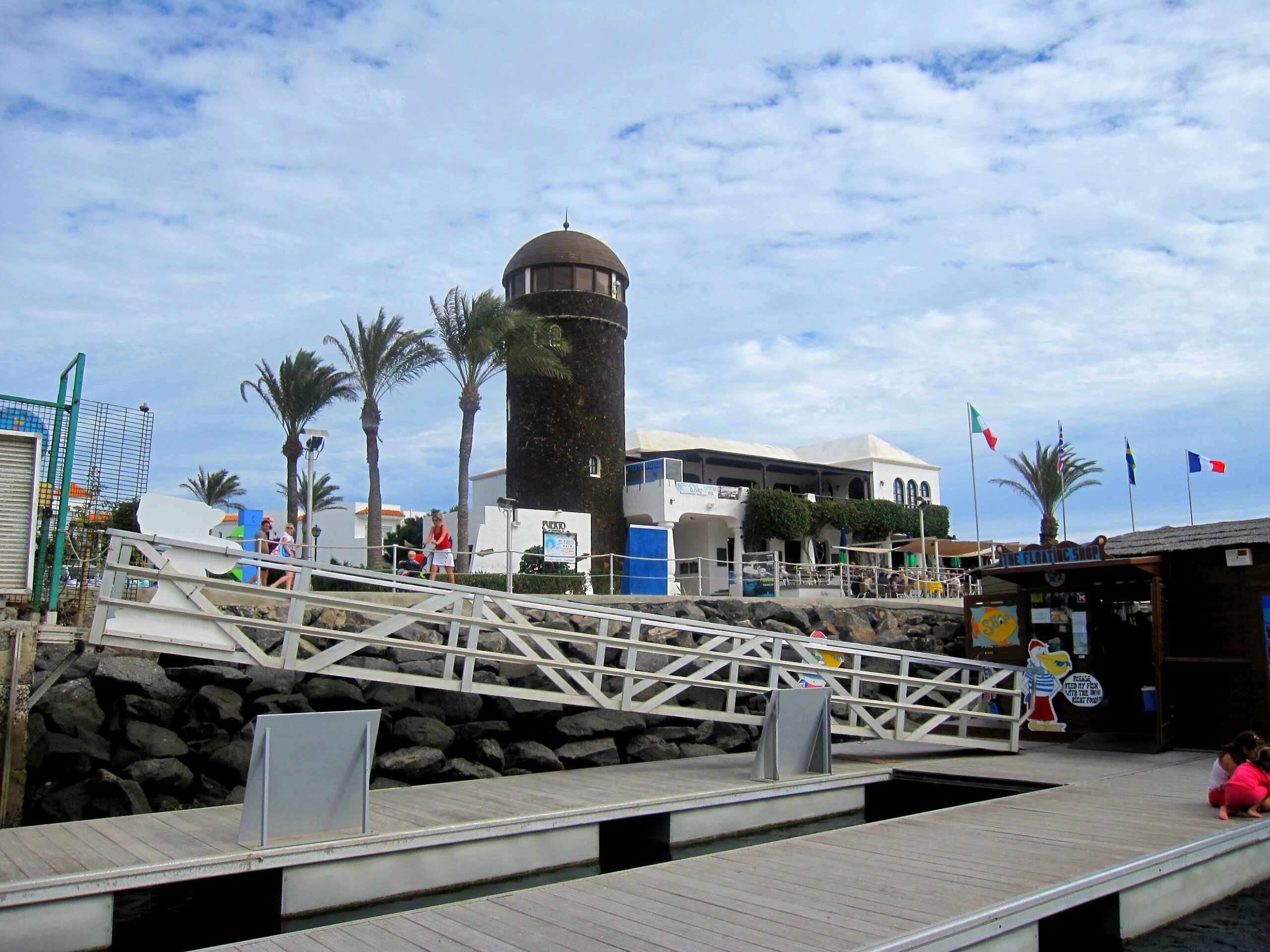 The historic tower at Castillo Beach overlooks the waterfront promenade with its distinctive architecture and palm-lined setting.