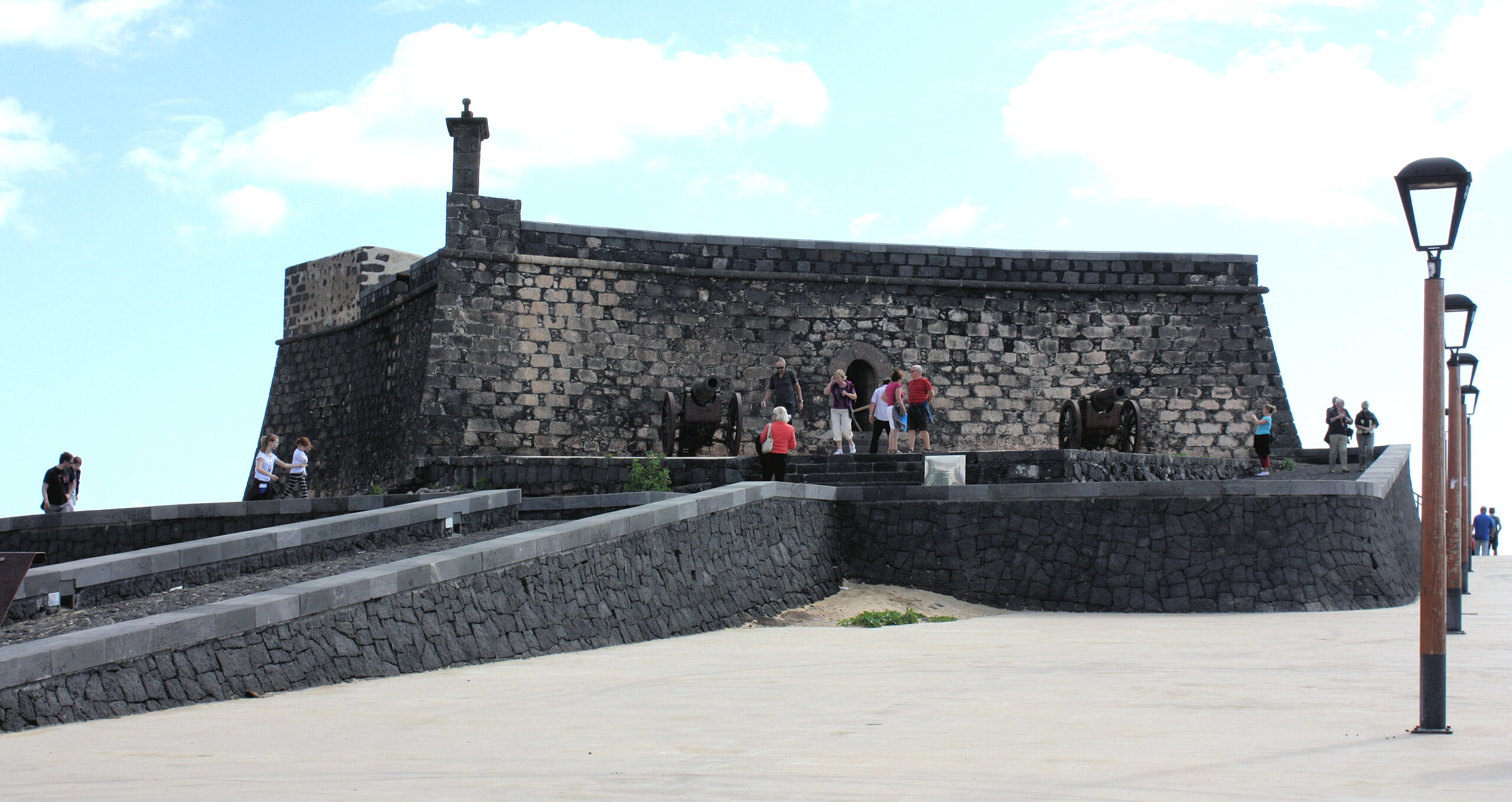 Castillo de San Gabriel, a 16th-century volcanic stone fortress, rises from the harbor in Arrecife with its distinctive watchtower and defensive walls.