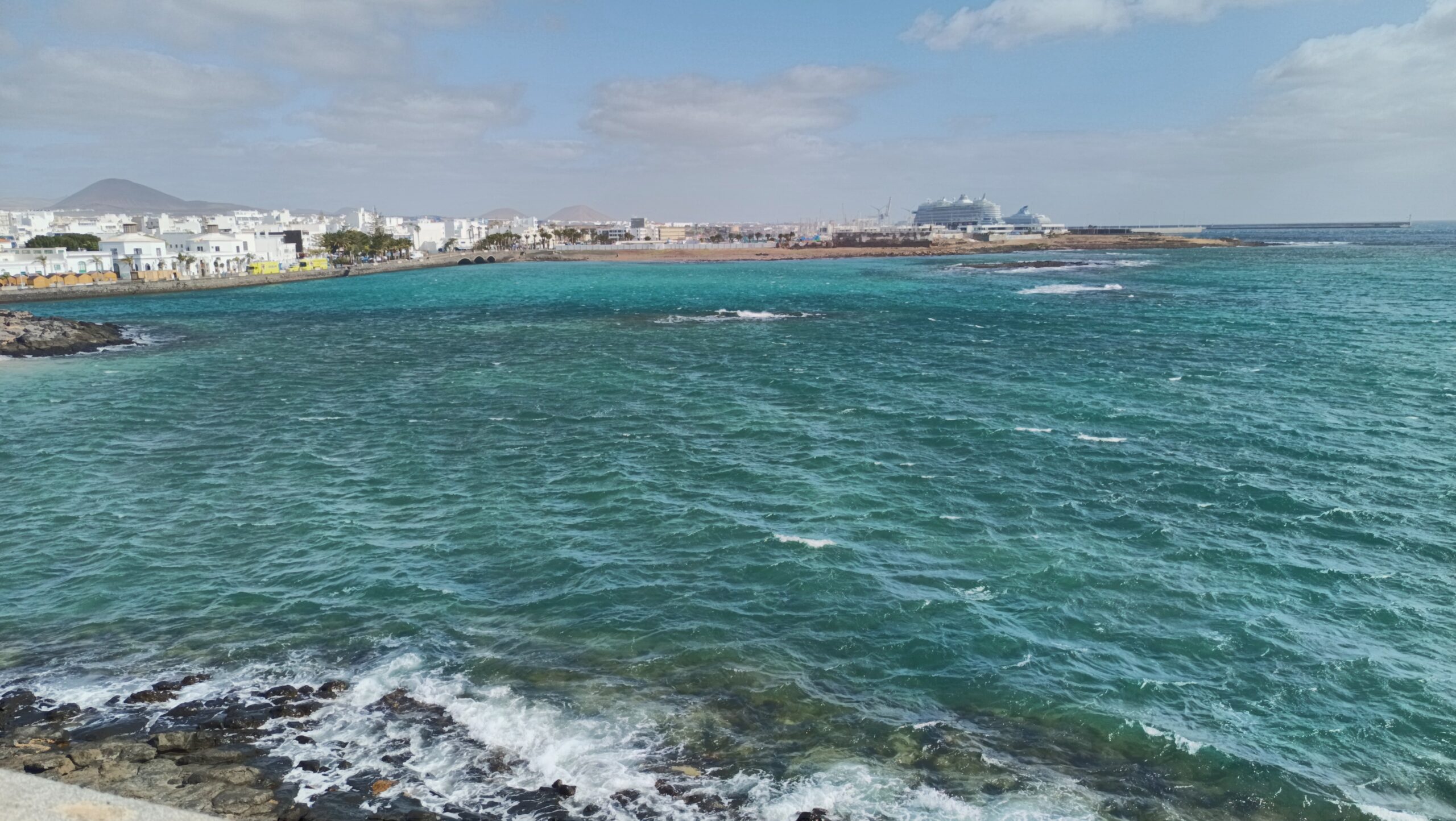 The crystal-clear waters and whitewashed coastal architecture of Arrecife showcase the island's distinctive blend of natural beauty and traditional Canarian design.