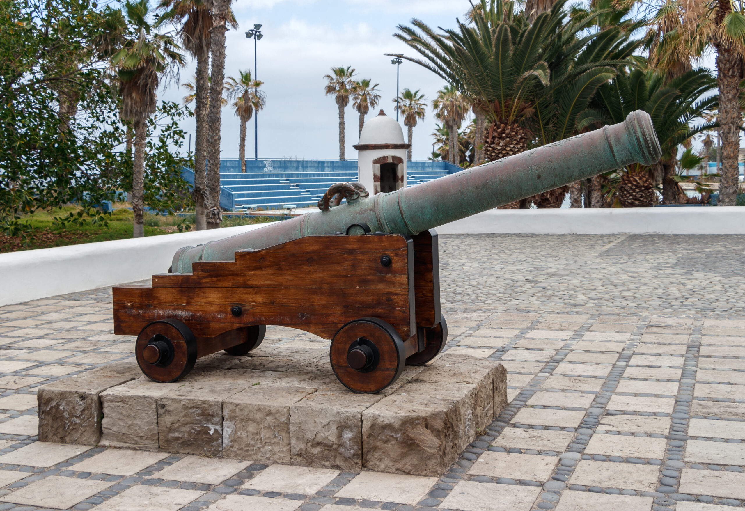 A restored cannon on display at Castillo San Felipe, pointing seaward across the palm-fringed grounds of this 17th-century fortress.