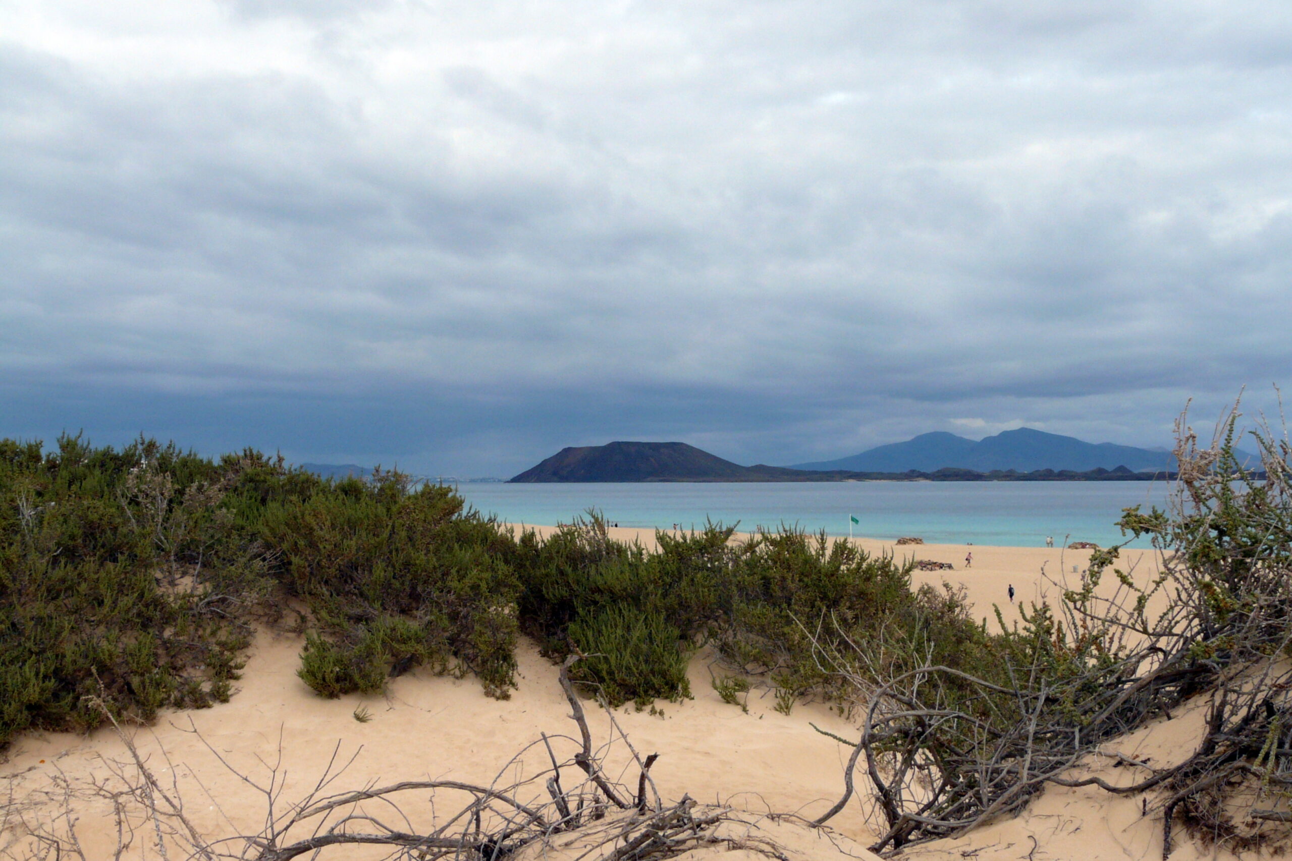 The Corralejo Dunes stretch along Fuerteventura's northern coast, with views across the water toward nearby volcanic islands.