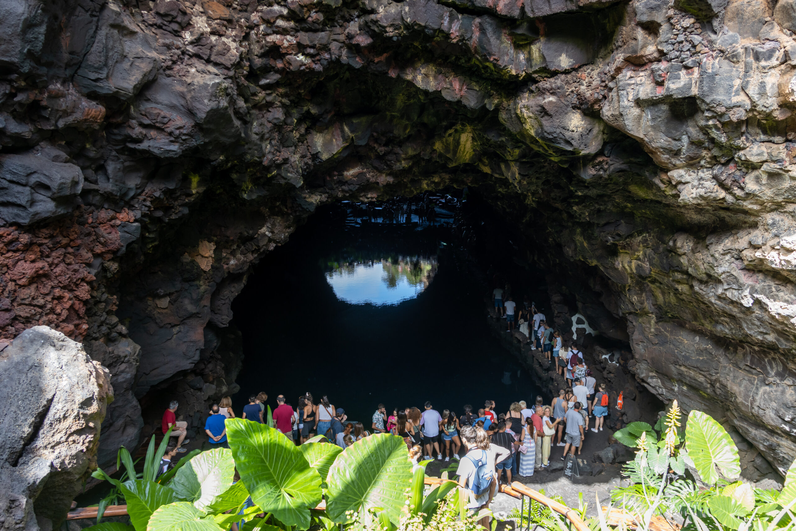 Cueva de Los Verdes reveals its dramatic volcanic rock formations and cavernous interior, with natural light filtering through openings above the visitor pathway.