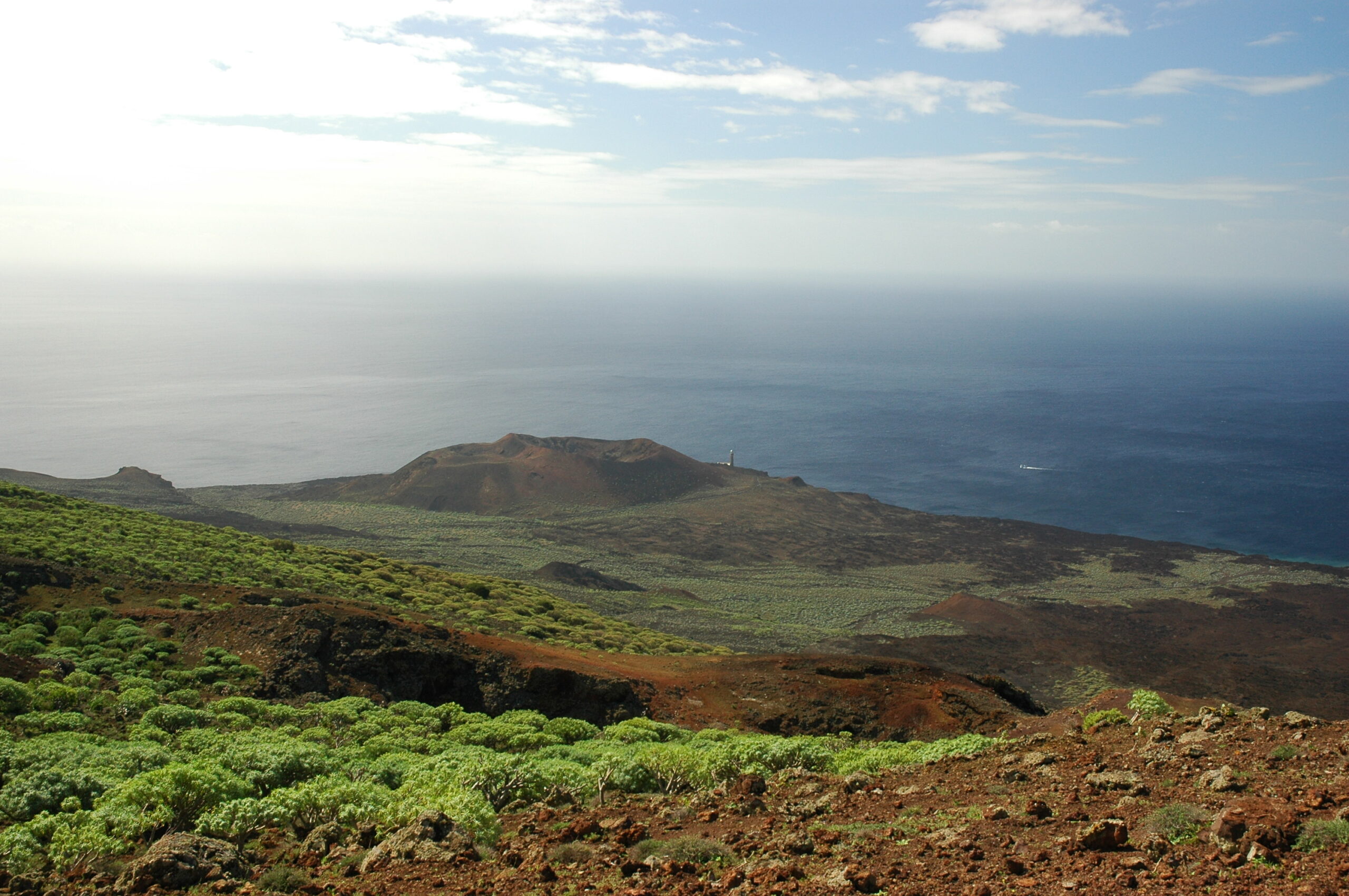 The rugged volcanic terrain of El Hierro's western coast, featuring distinctive cinder cones and sparse vegetation typical of the island's arid landscape.