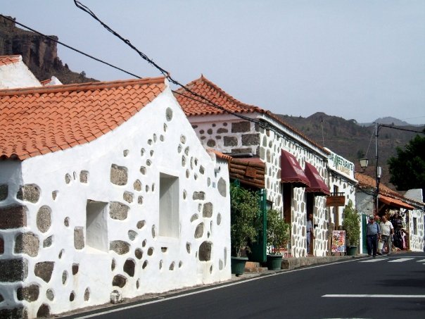 Traditional whitewashed stone buildings with characteristic tile roofs in the historic mountain village of Fataga.