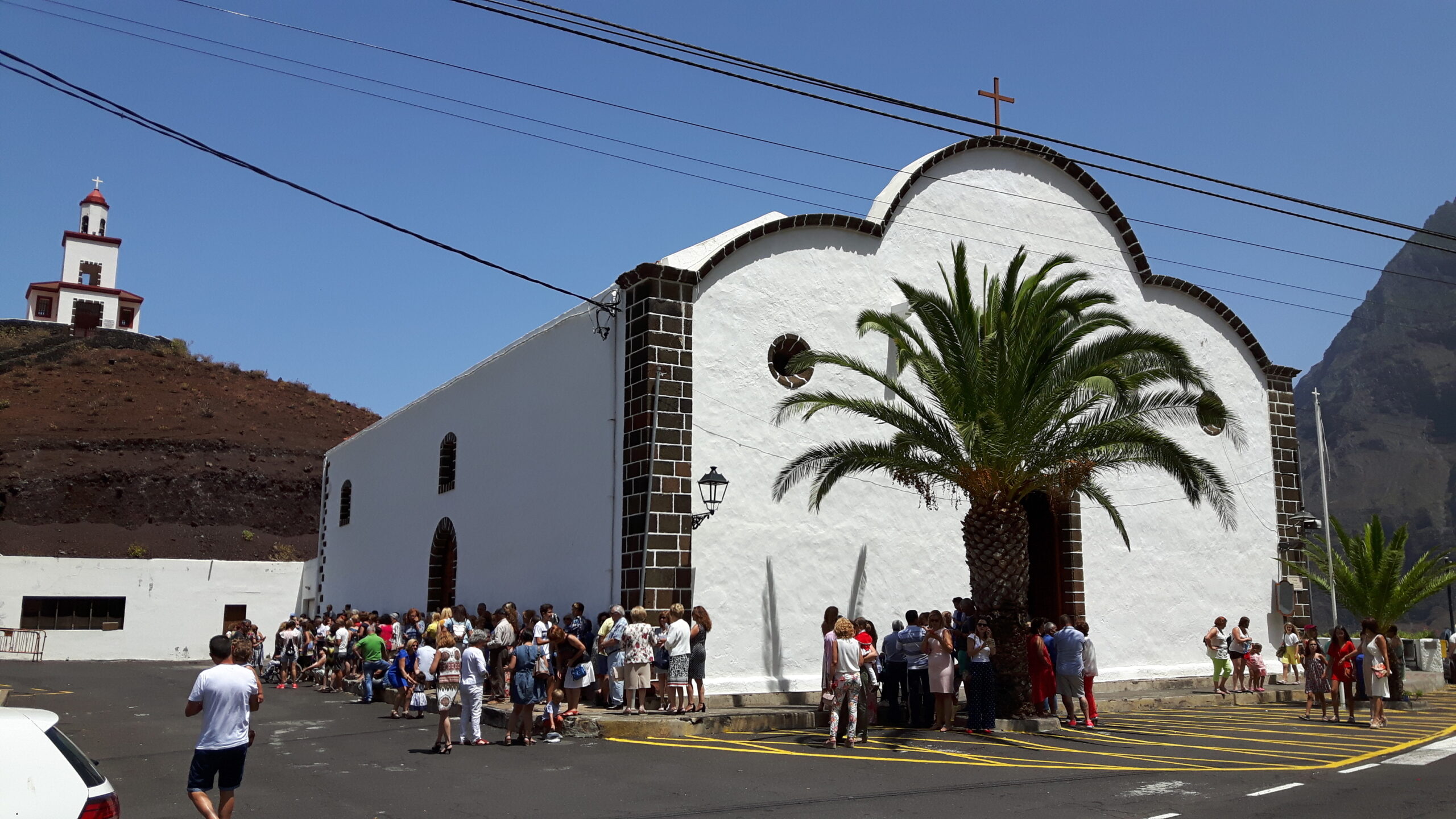 The distinctive white church in Frontera Village draws visitors who gather in the sunny plaza during the day.