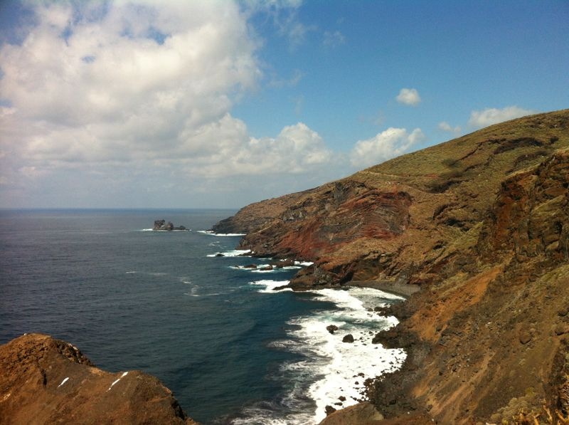 The dramatic cliffs of Garafía Coast showcase La Palma's volcanic geology meeting the Atlantic, with white-water waves breaking against the rocky shoreline.