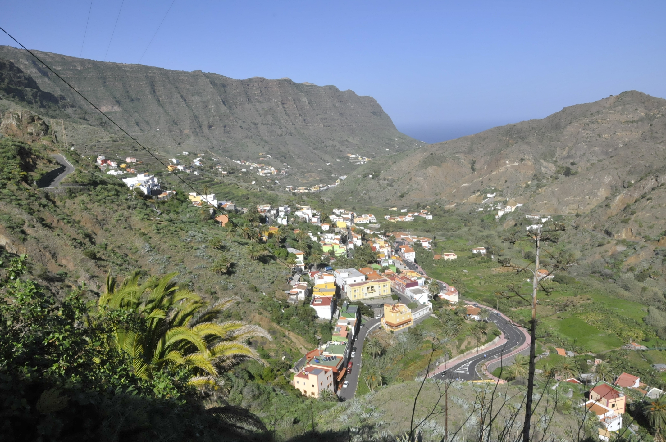 The verdant Hermigua Valley descends toward the coast, its steep slopes dotted with traditional houses and terraced vegetation.