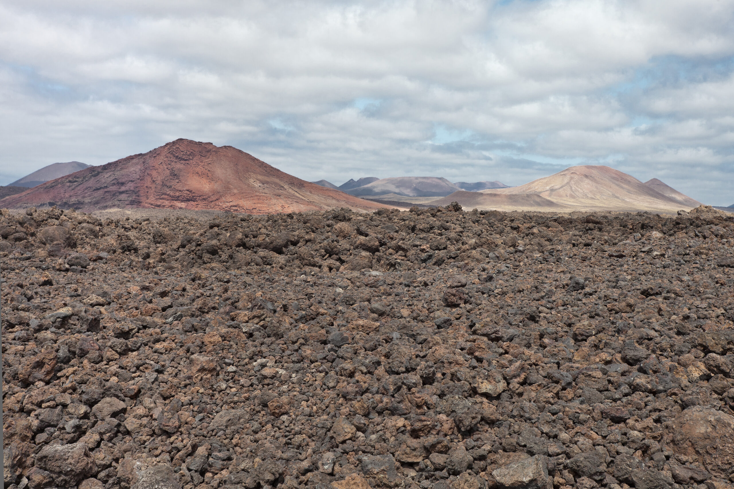 The stark volcanic landscape at Los Hervideros showcases Lanzarote's dramatic geological heritage, with expansive lava flows and distinctive cinder cones characteristic of the island's volcanic terrain.