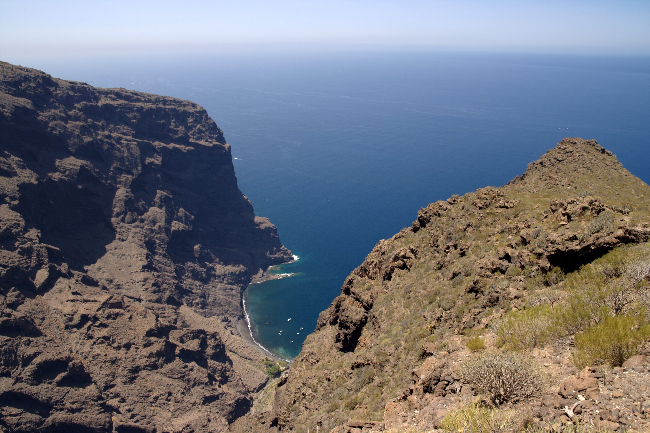 Masca Valley's dramatic ravine cuts through volcanic terrain toward the sea, offering breathtaking views across the coastline.