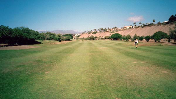 The championship golf course at Maspalomas sits beside the dune system, framed by palms and desert vegetation.