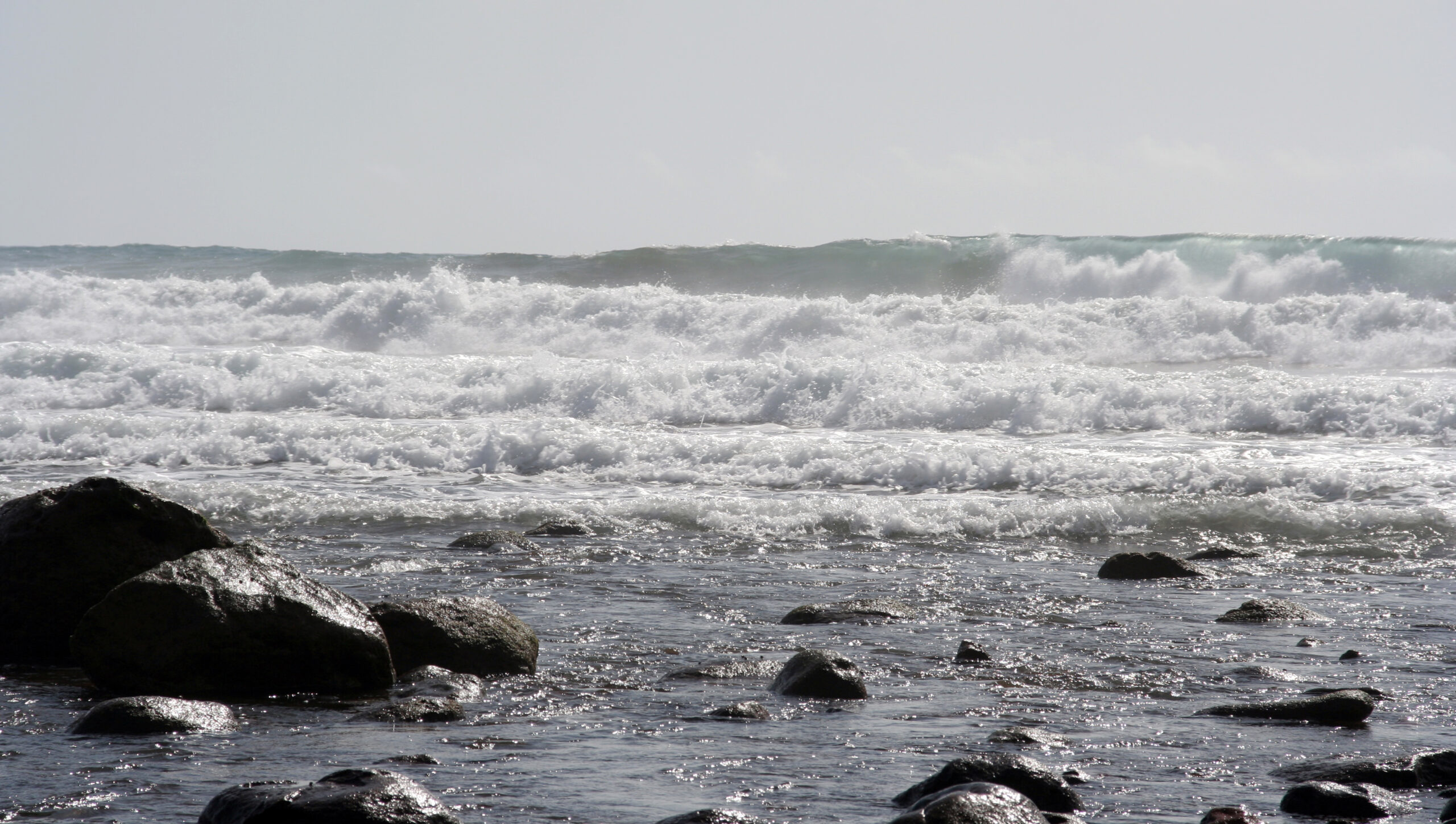Atlantic waves break against the volcanic rock shelves that line the Meloneras Promenade.