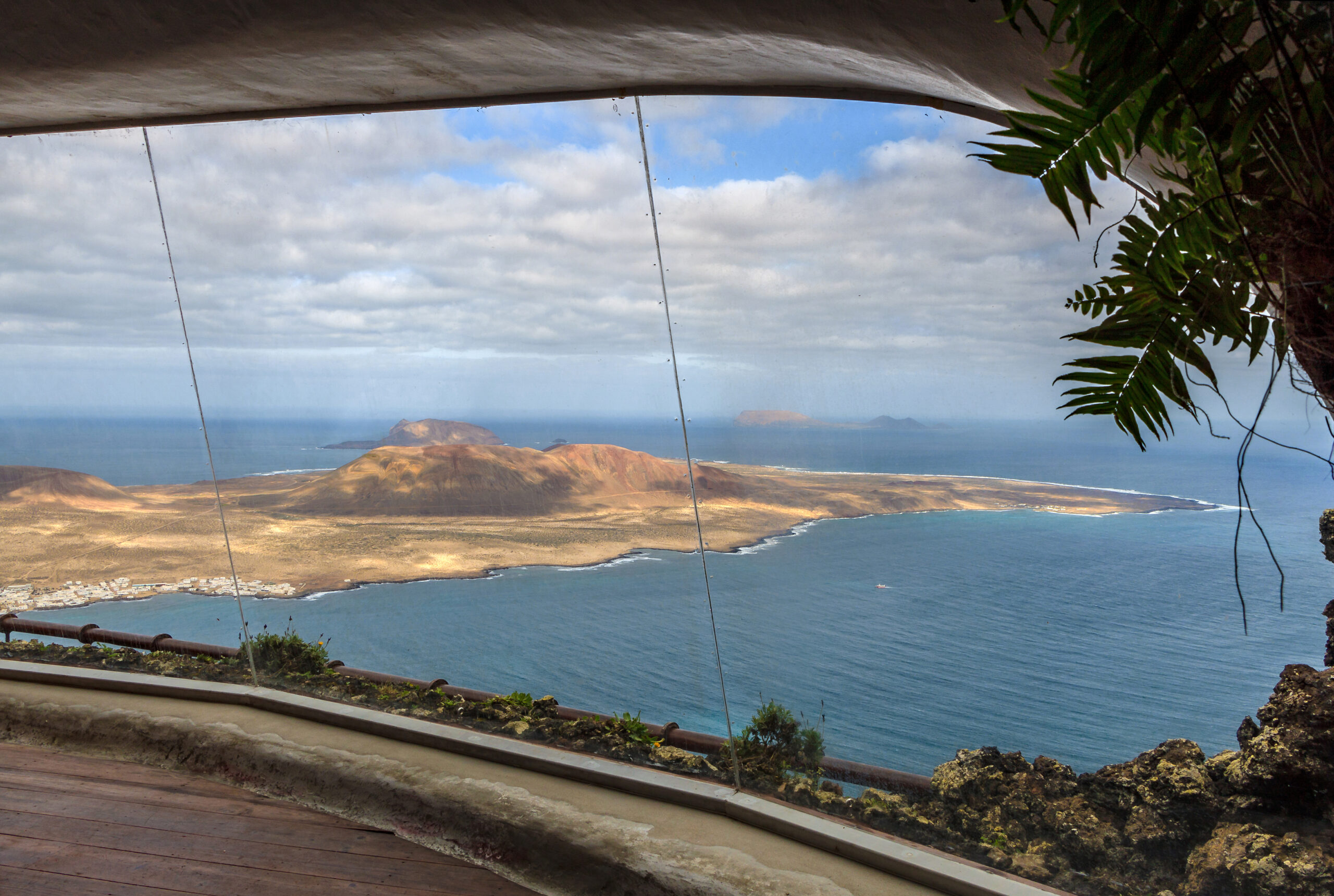 The panoramic vista from Mirador del Río frames Lanzarote's dramatic volcanic terrain and the sparkling Atlantic waters beyond.