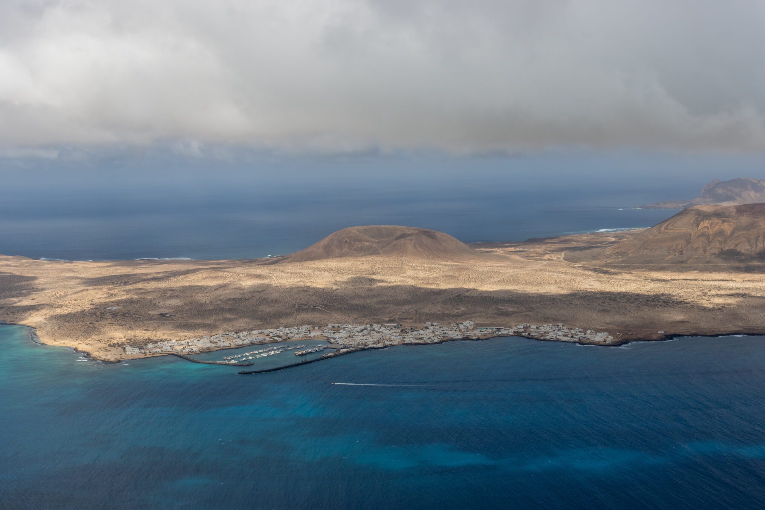 The dramatic volcanic landscape of Lanzarote's northern coast, with its distinctive arid terrain meeting the Atlantic Ocean.