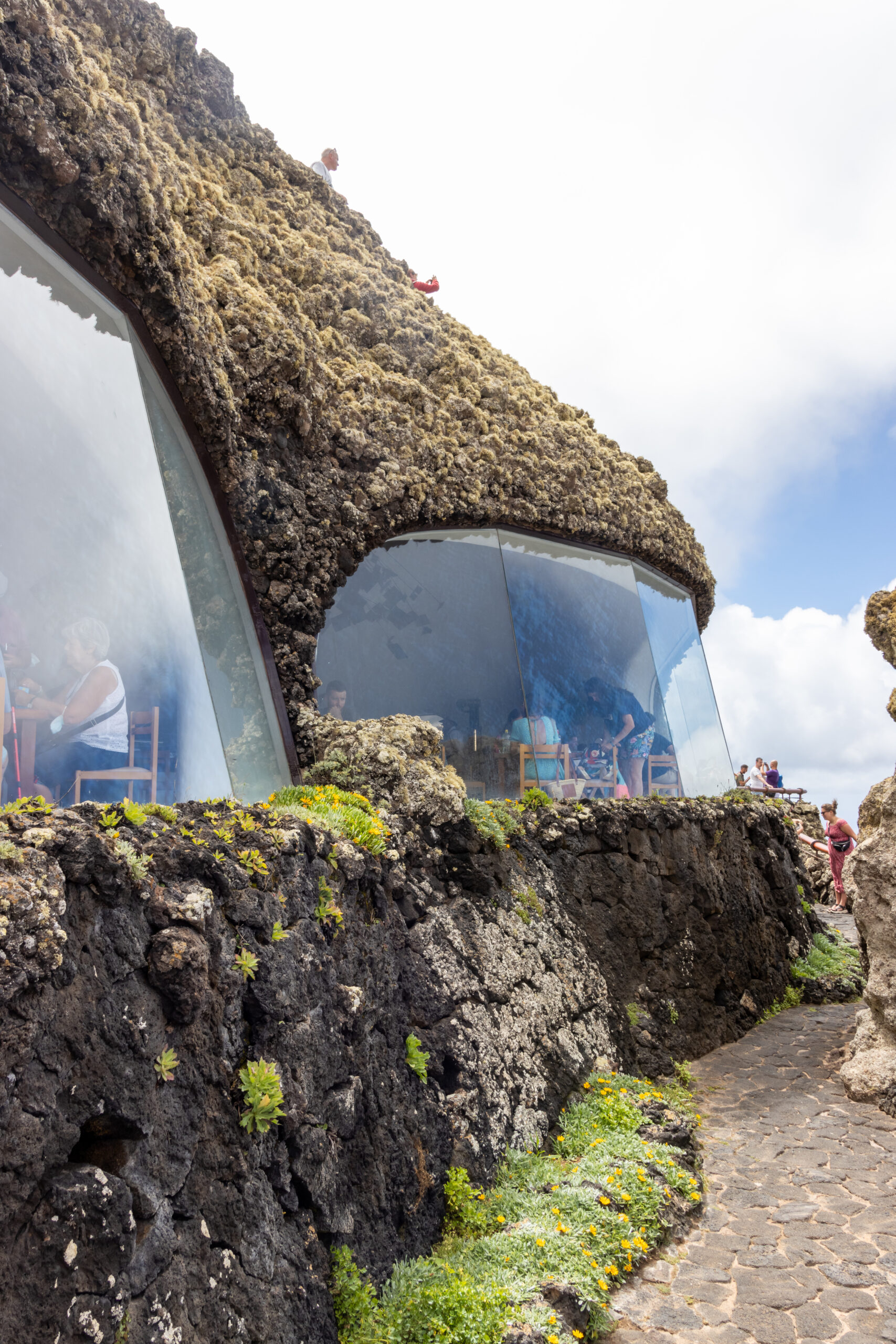 The distinctive glass and volcanic stone architecture of Mirador del Río frames panoramic views of the surrounding landscape.