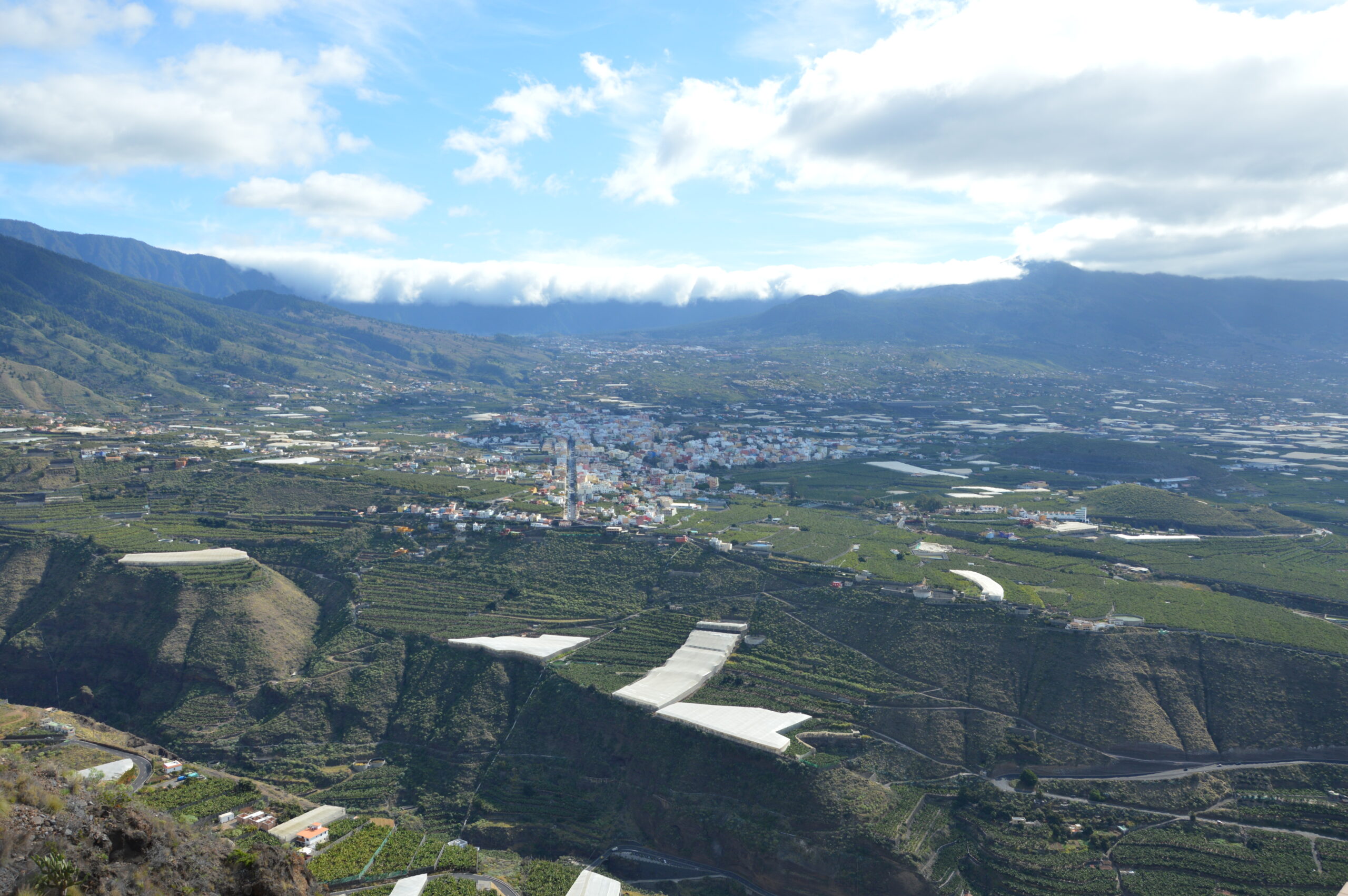 The Mirador del Time offers sweeping views across La Palma's verdant valley, revealing the serpentine course of the river and the patchwork of cultivated land leading toward the coast.