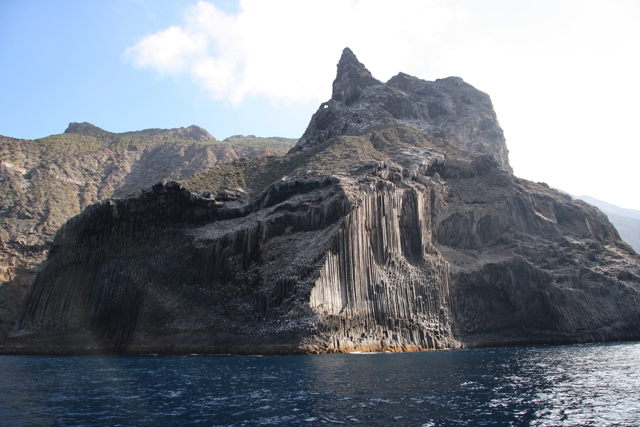 The striking hexagonal basalt columns of Los Órganos rise dramatically from the ocean, a natural monument formed by ancient volcanic activity.