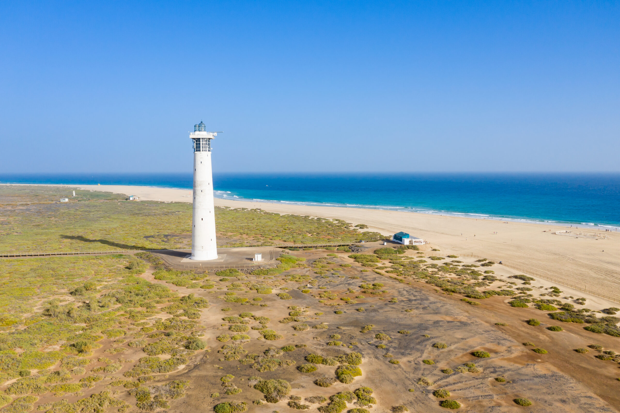 The Morro Jable Lighthouse stands sentinel over the southern tip of Fuerteventura, with pristine beaches and crystalline waters stretching along the coastline.