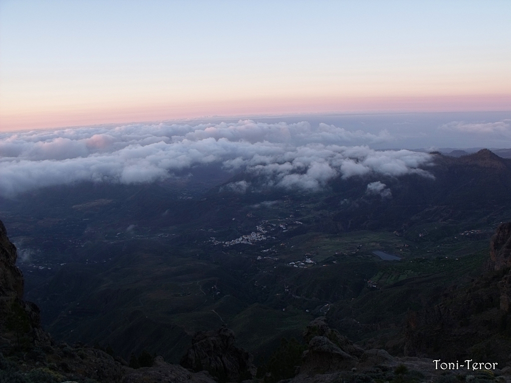 From Pico de las Nieves, the highest point in Gran Canaria, a blanket of clouds obscures the lowlands at sunrise, creating a dramatic sea-of-clouds vista.