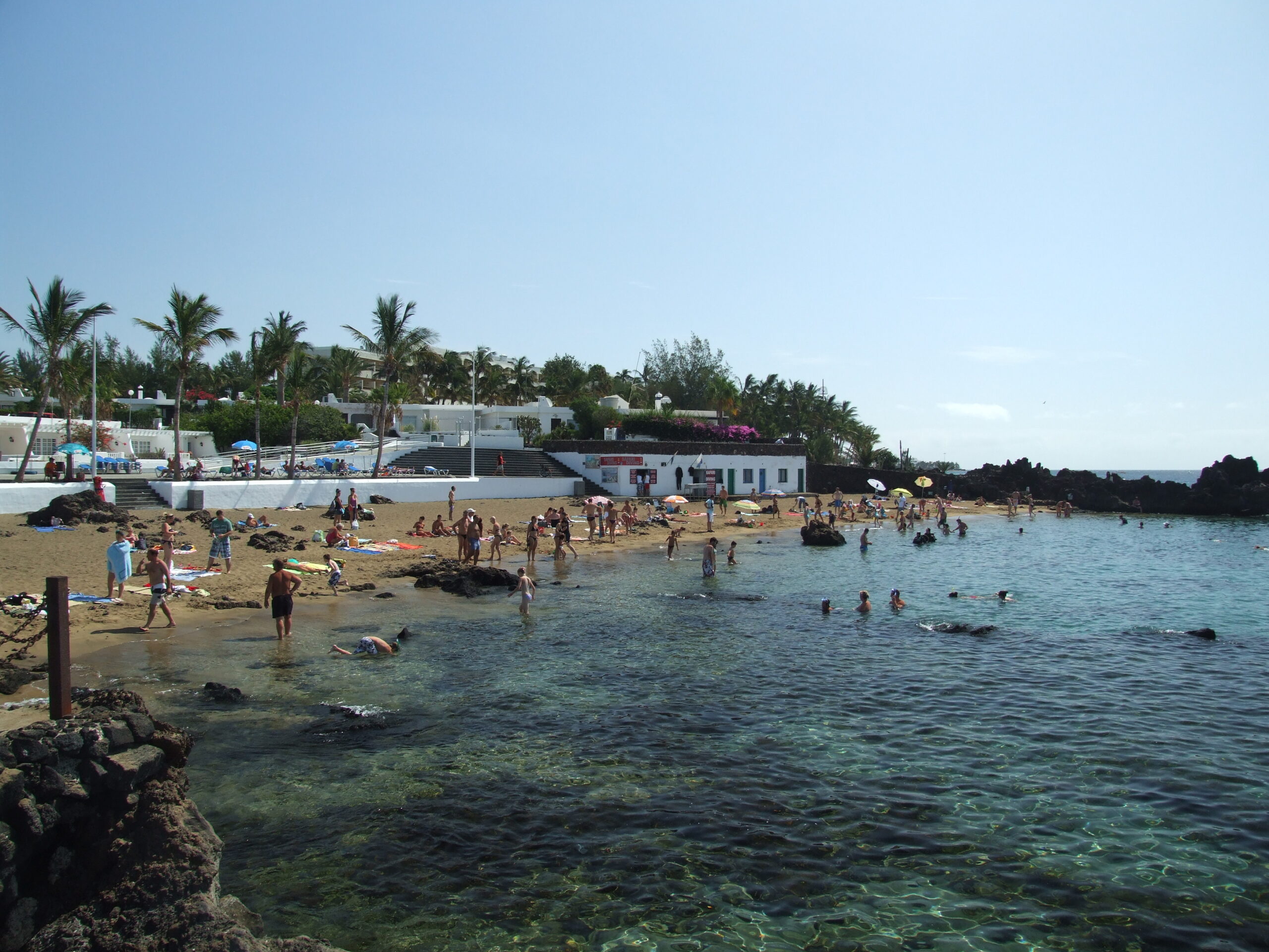Playa Chica's sheltered sandy beach and shallow waters attract swimmers and sunbathers year-round, backed by local beachfront amenities.