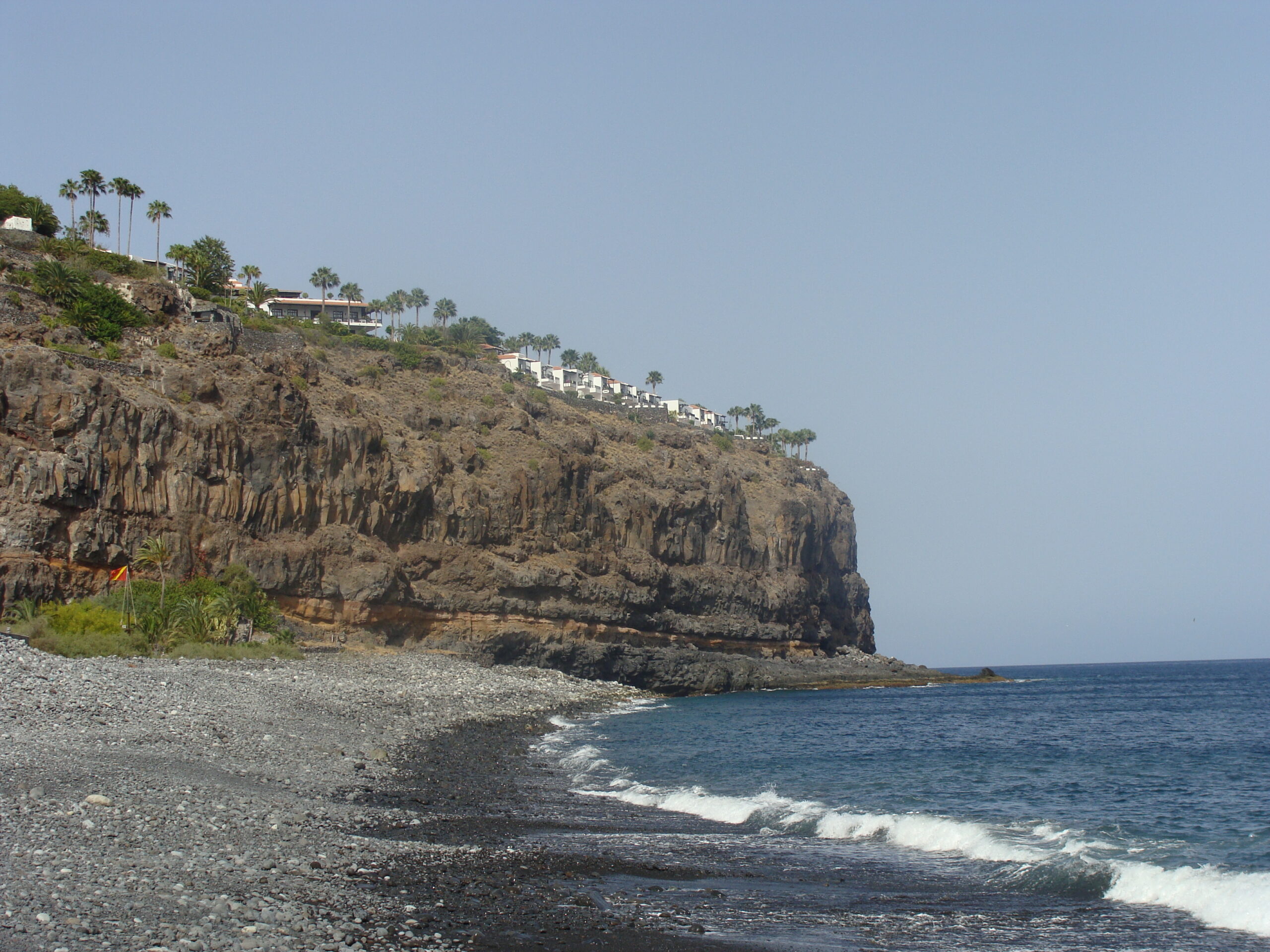 The fishing village of Playa de Santiago sits along a wide volcanic bay, its waterfront shaped by boats, breakwaters and sun-baked slopes.