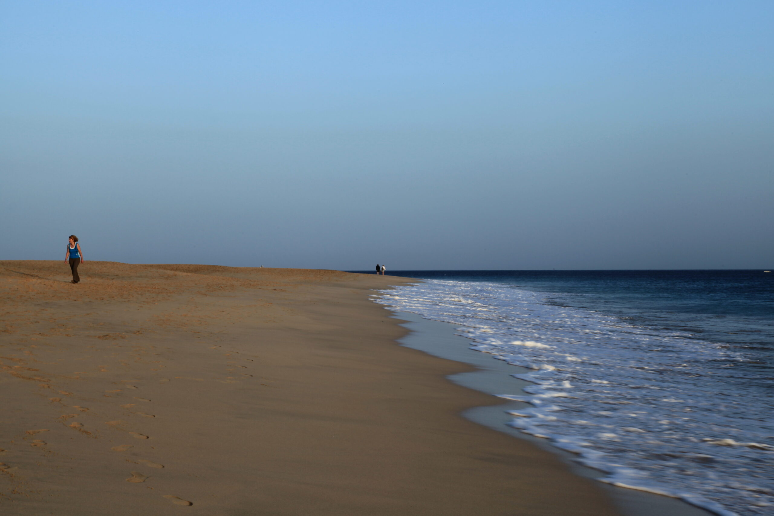 Playa del Matorral stretches across Jandía with pristine golden sand and calm Atlantic waters beneath clear skies.