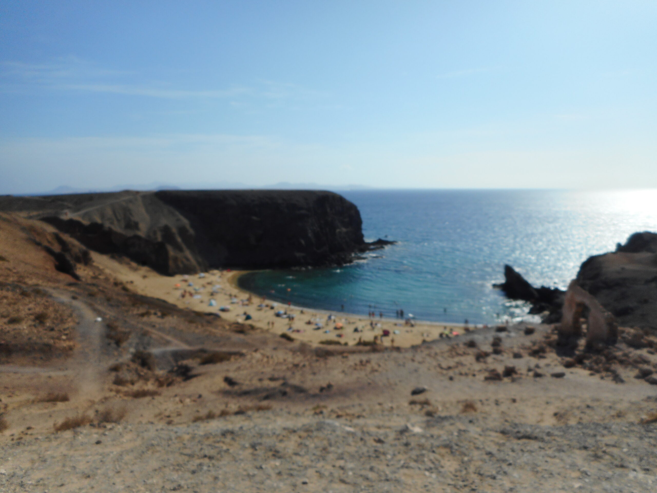 Playa del Pozo offers a sheltered cove backed by striking volcanic cliffs and dark lava formations characteristic of Lanzarote's geology.