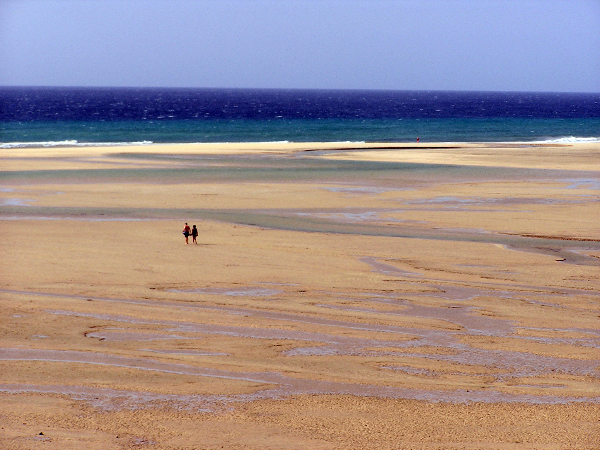 The expansive sands of Playa Esmeralda stretch between tidal pools and rolling Atlantic waves, offering solitude and space along Fuerteventura's southern coast.