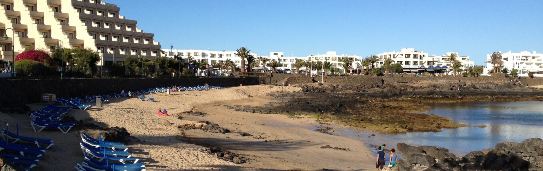 View from "Avenida Los Cocederos" to "Playa del Jablillo". Located in Costa Teguise. Its waters are closed from the sea by a set of rocks that even though allow the sea water to renovate.
