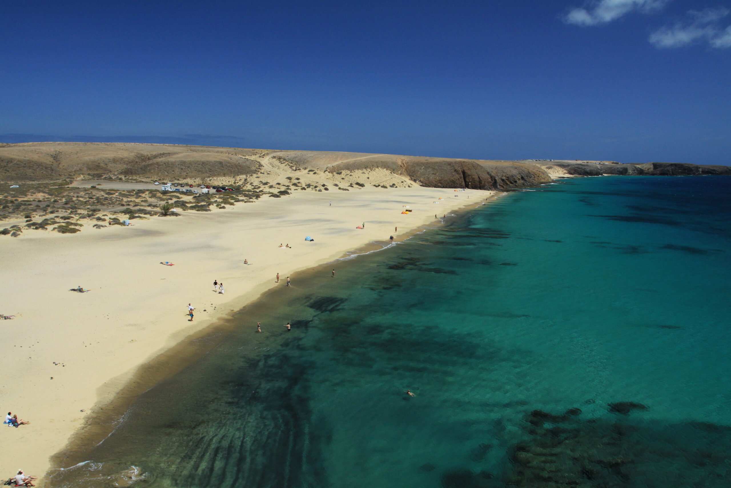 Playa Mujeres offers pristine white sand and crystal-clear turquoise waters backed by dramatic volcanic hills.