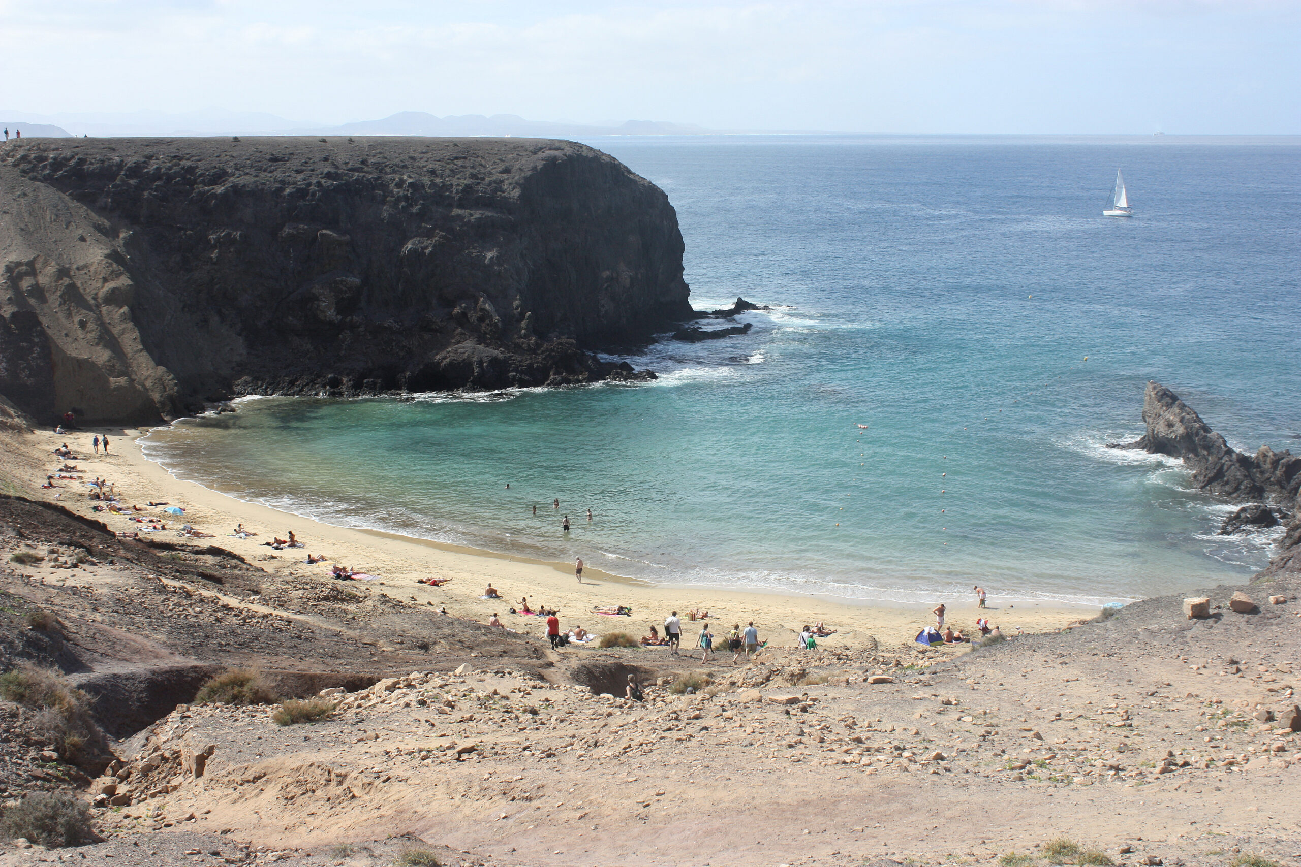 Playa Papagayo's secluded cove offers crystal-clear waters and dramatic volcanic cliffs that shield the beach from strong winds.