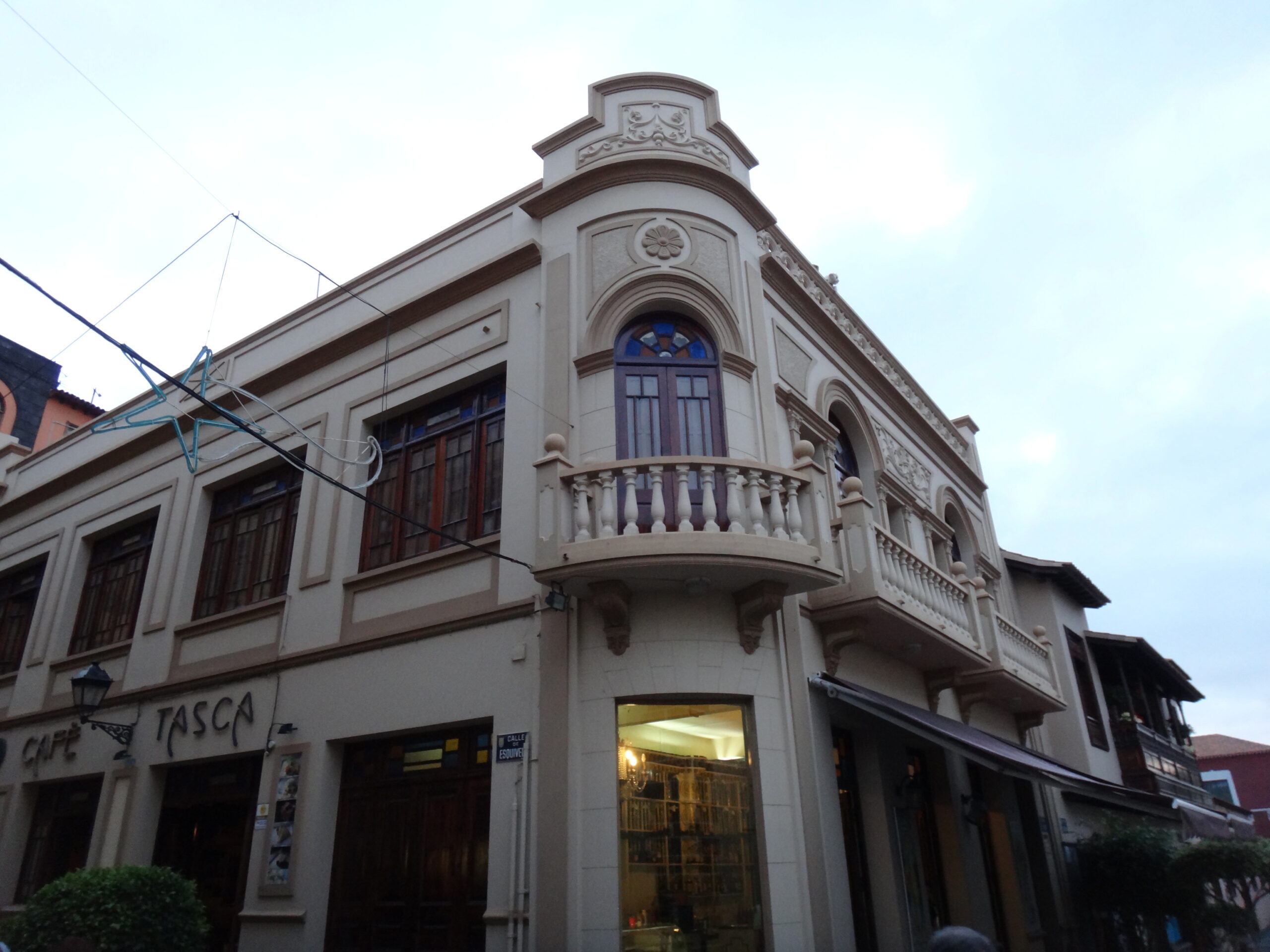 A beautifully preserved colonial-era corner building in Puerto de la Cruz's Old Town, featuring distinctive architectural details including a rounded turret and traditional wooden balconies.