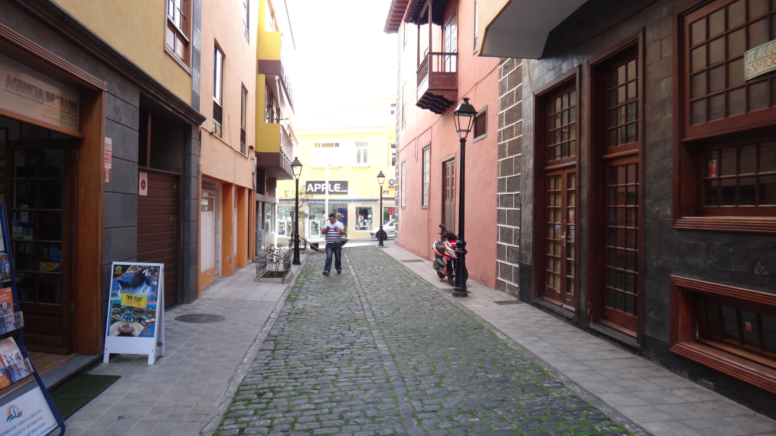 A quiet cobblestone lane in Puerto de la Cruz's historic old town, lined with traditional Canarian colonial buildings featuring wooden doors and shutters.