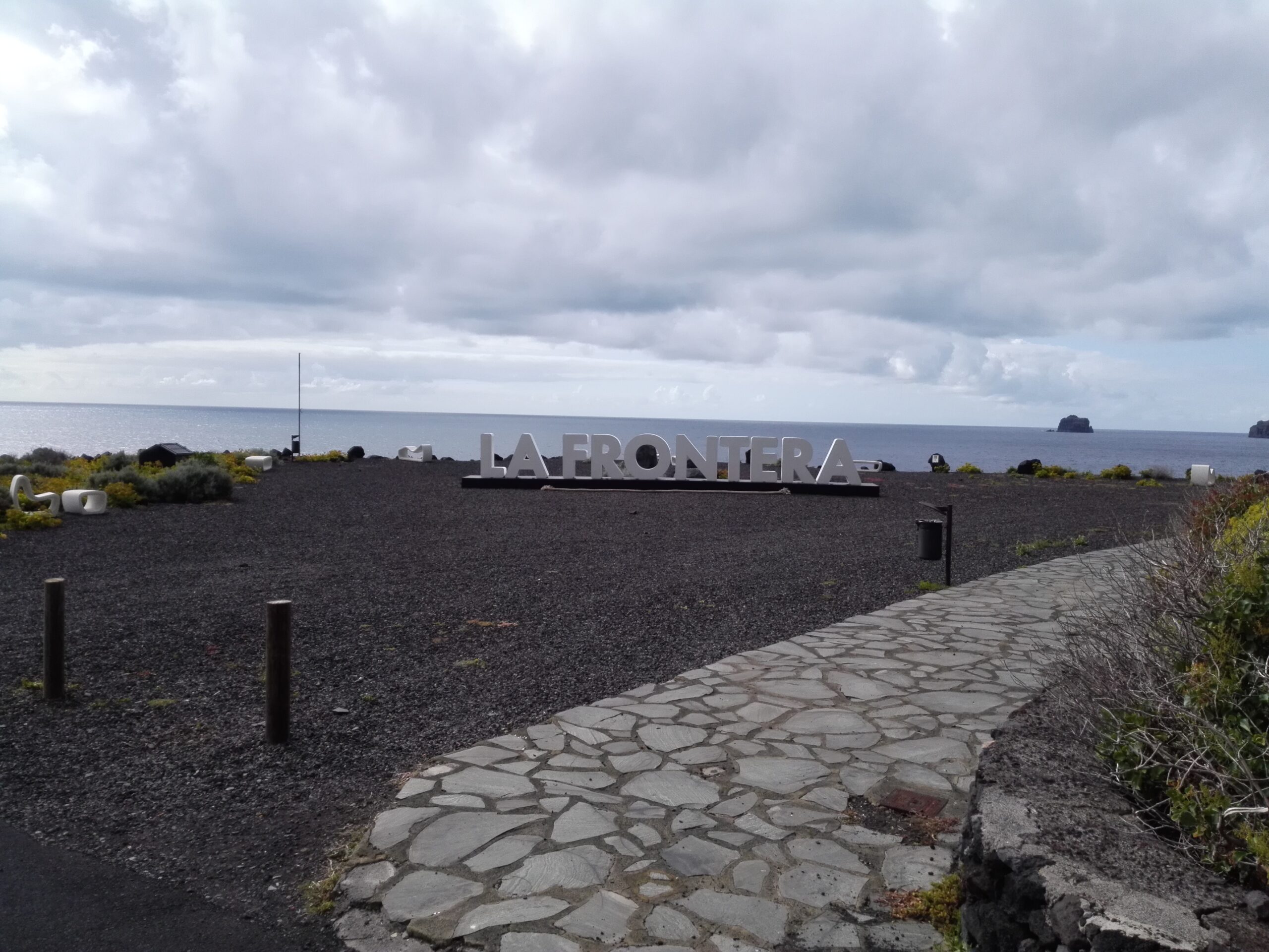 The Lafrontera landmark sign sits on the dramatic black volcanic beach at Punta Grande, overlooking the Atlantic Ocean.