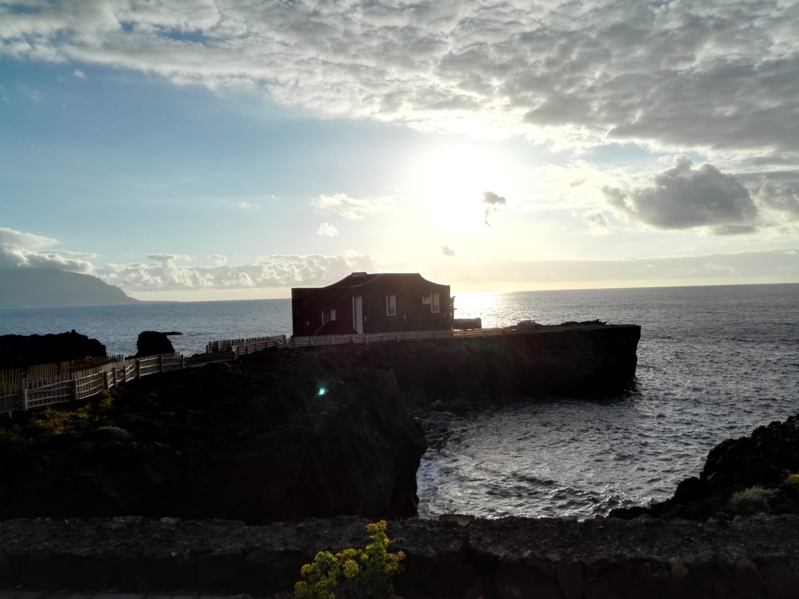 The distinctive Punta Grande Hotel sits dramatically on volcanic rock formations overlooking the Atlantic, accessible via a wooden boardwalk on El Hierro's rugged northern coast.