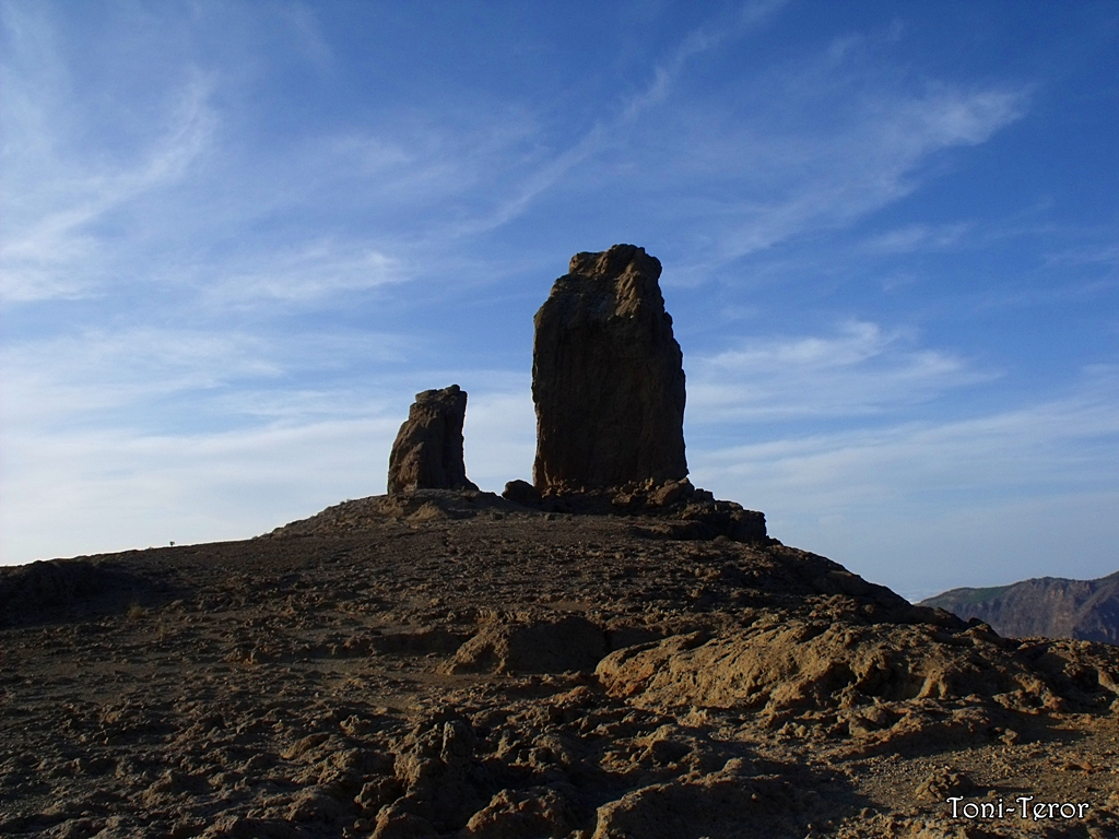 Roque Nublo's distinctive twin rock formations stand prominently above the surrounding volcanic landscape in Gran Canaria.