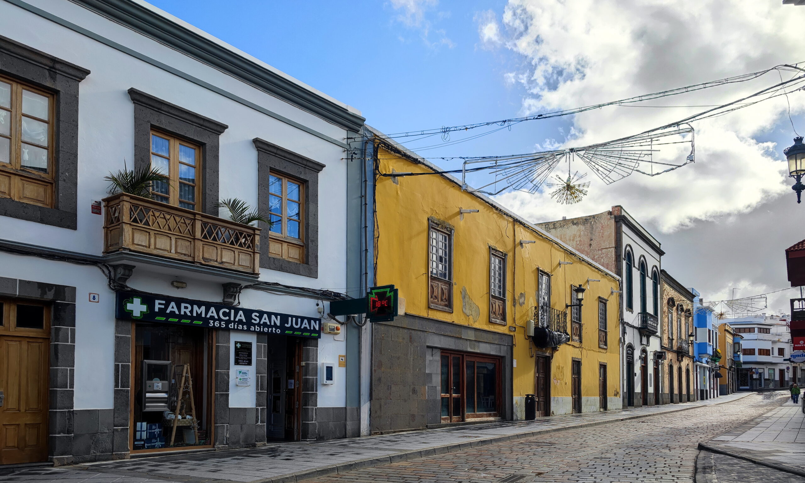 A traditional Canarian colonial street in Telde featuring colorful historic buildings with characteristic wooden balconies and period architecture.