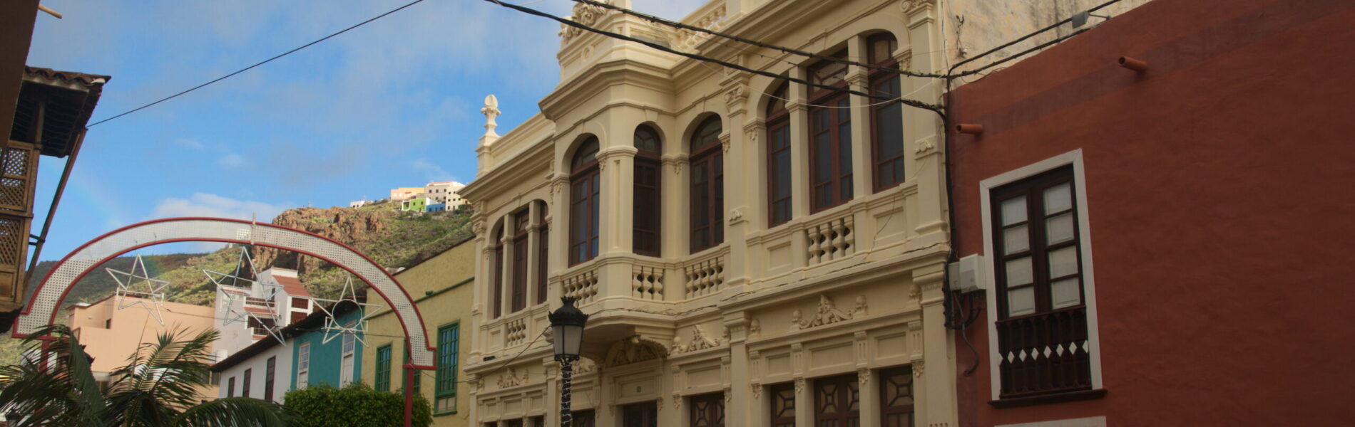 Cream-colored neoclassical building on narrow cobblestone street