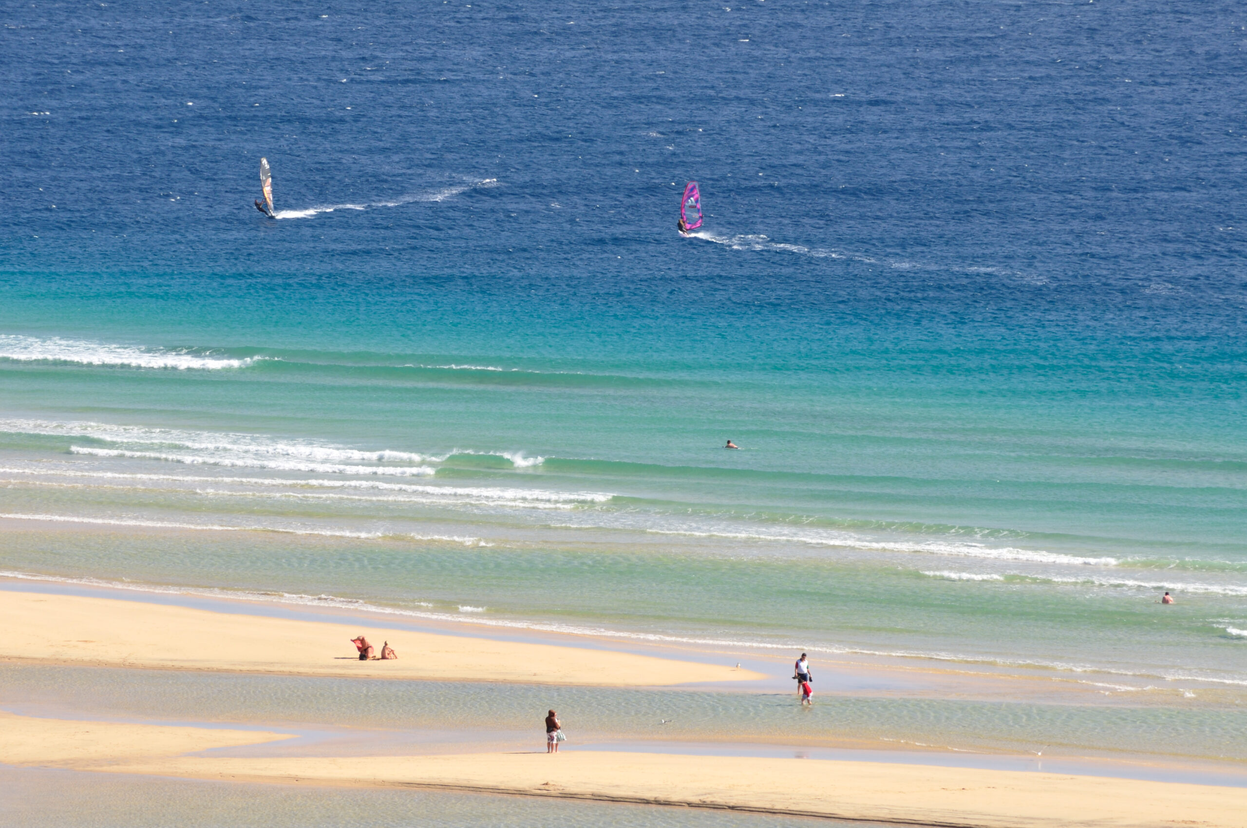 Sotavento Beach offers calm, crystal-clear waters ideal for swimming and windsurfing, with golden sand and excellent conditions for water sports.