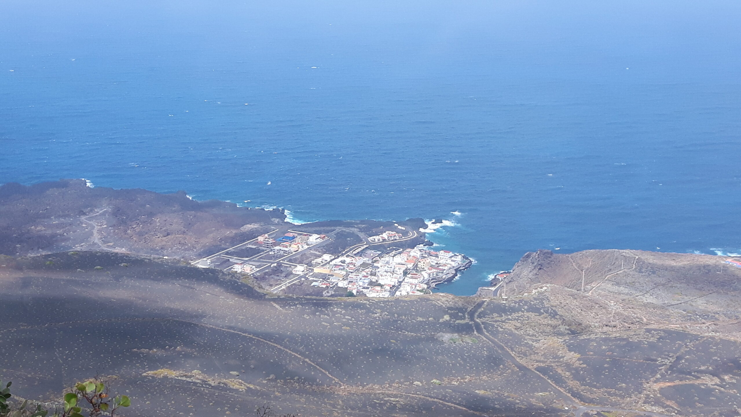 Tamaduste's whitewashed buildings cluster along the coast, surrounded by the volcanic landscape characteristic of El Hierro's dramatic terrain.