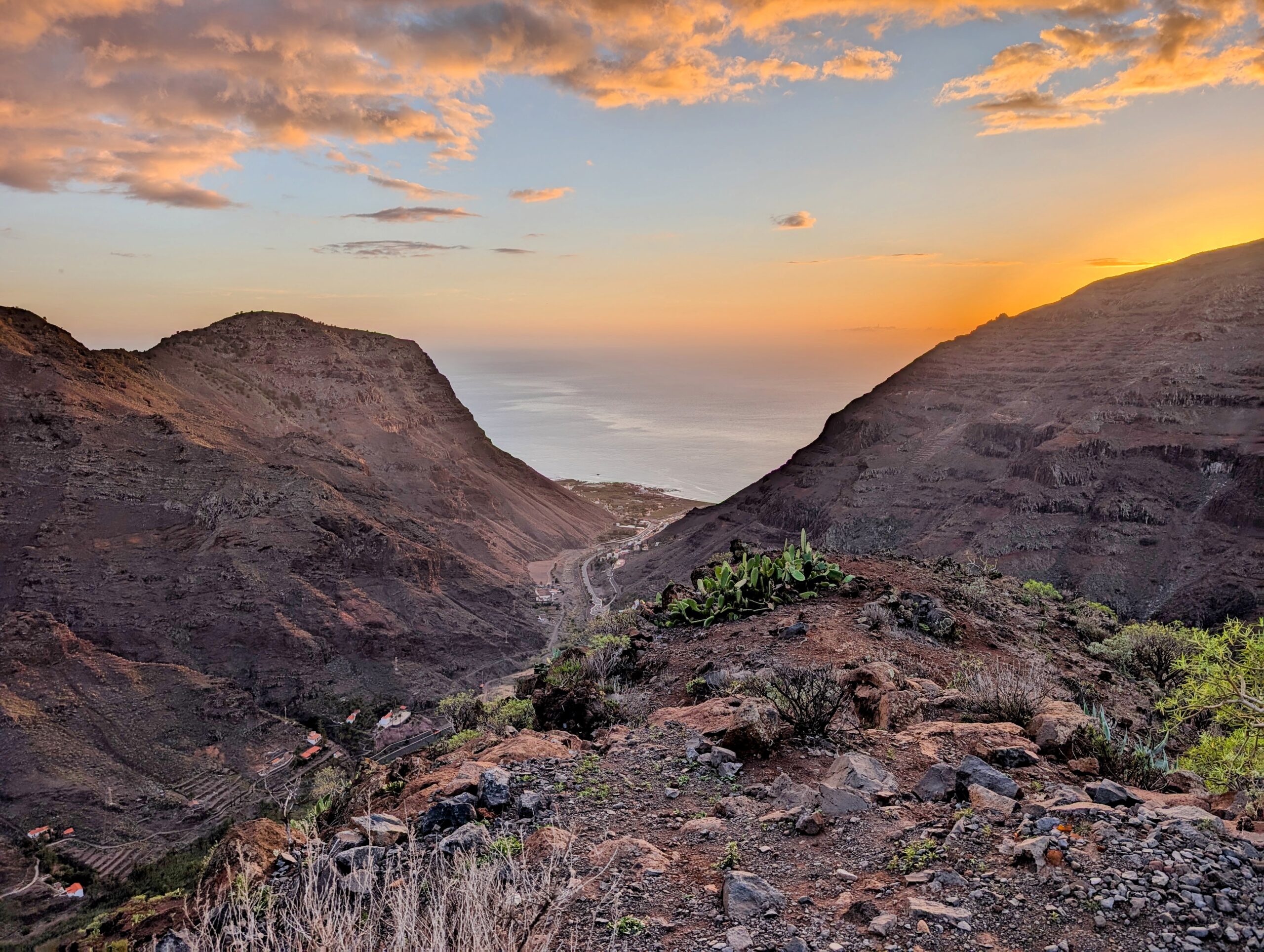 The dramatic Valle Gran Rey unfolds toward the coast at sunset, with volcanic ridges creating a natural amphitheater above the valley settlement.