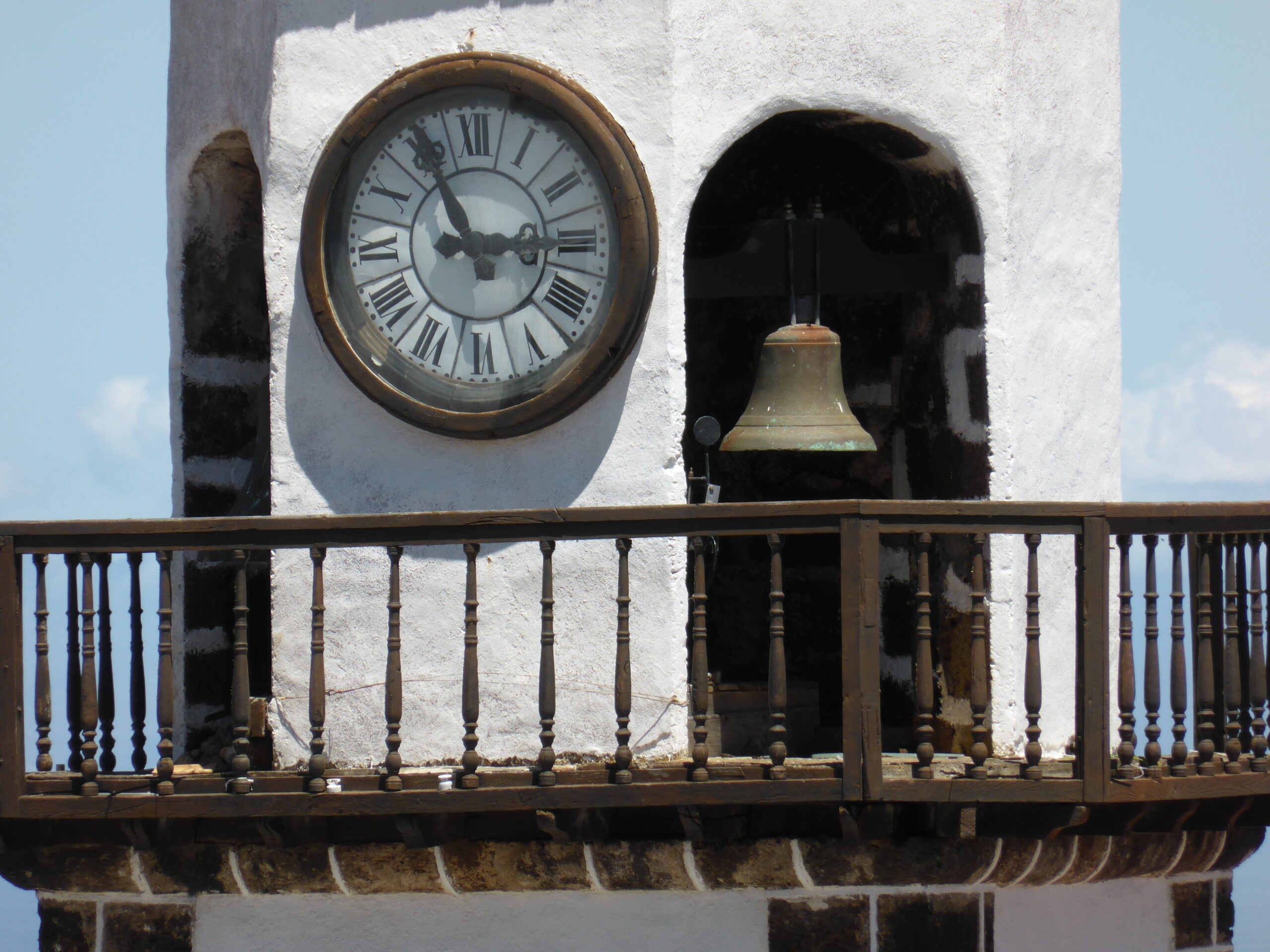 A traditional clock and bell adorn the whitewashed architecture of Valverde's Old Town on El Hierro.