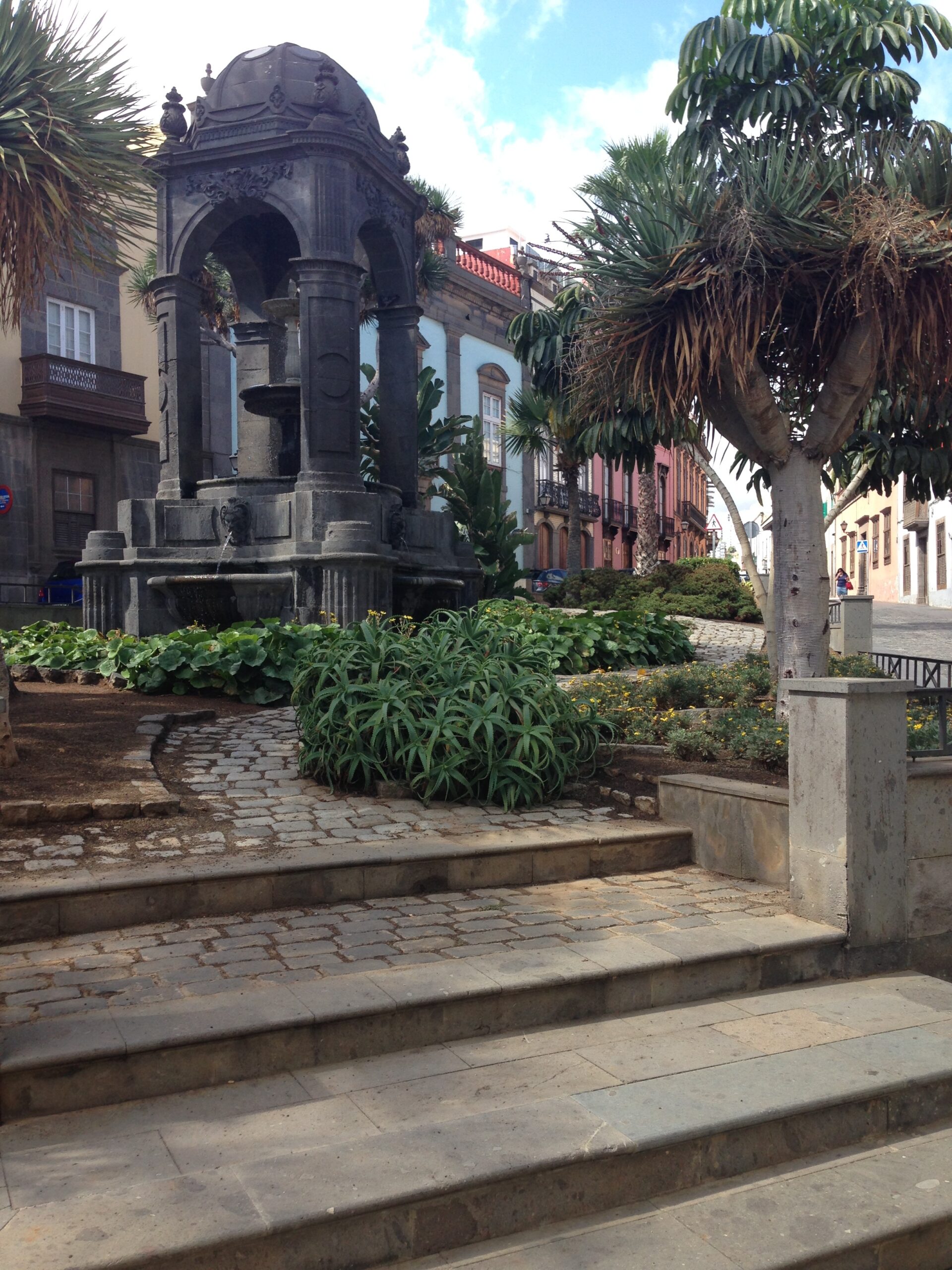 A domed stone kiosk stands in one of Vegueta’s central plazas, framed by palms and colonial-era façades.