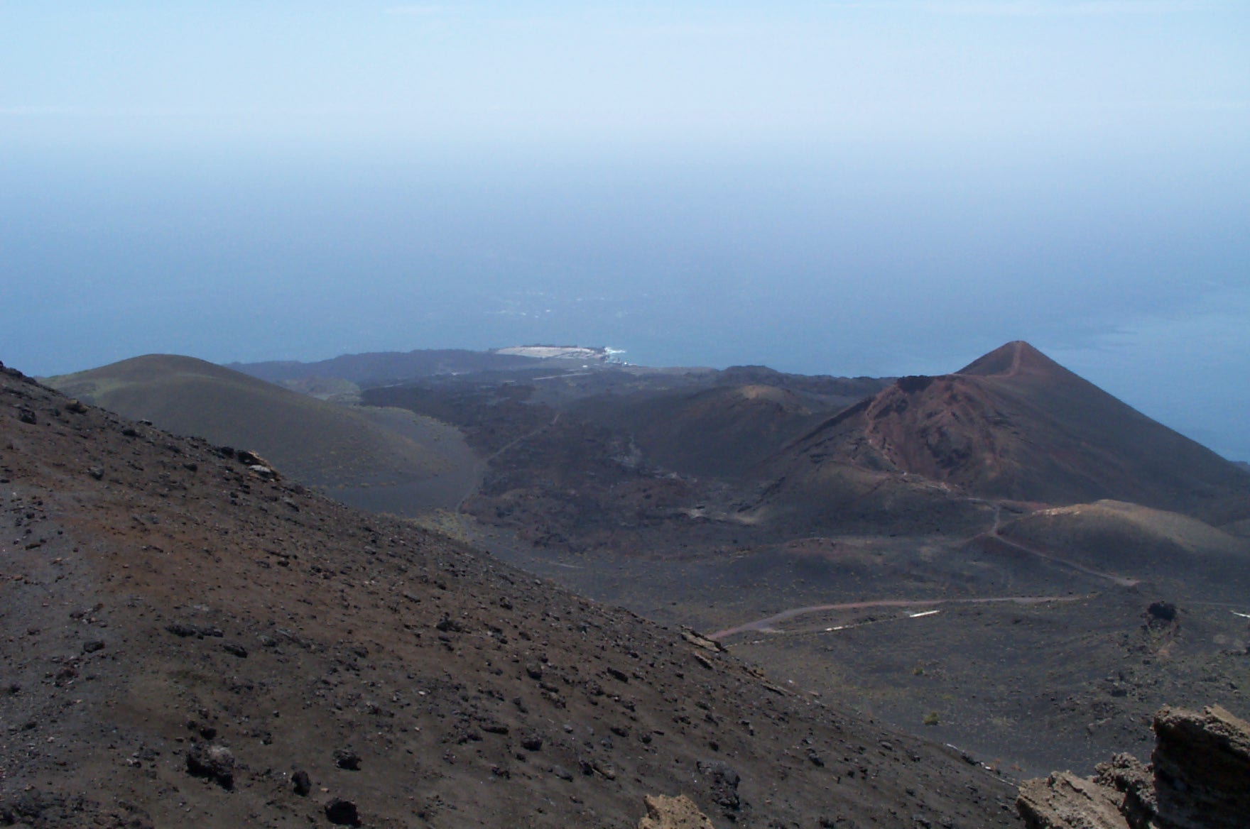 The dramatic volcanic landscape surrounding San Antonio volcano, with multiple cinder cones and expansive lava flows characteristic of La Palma's volcanic terrain.